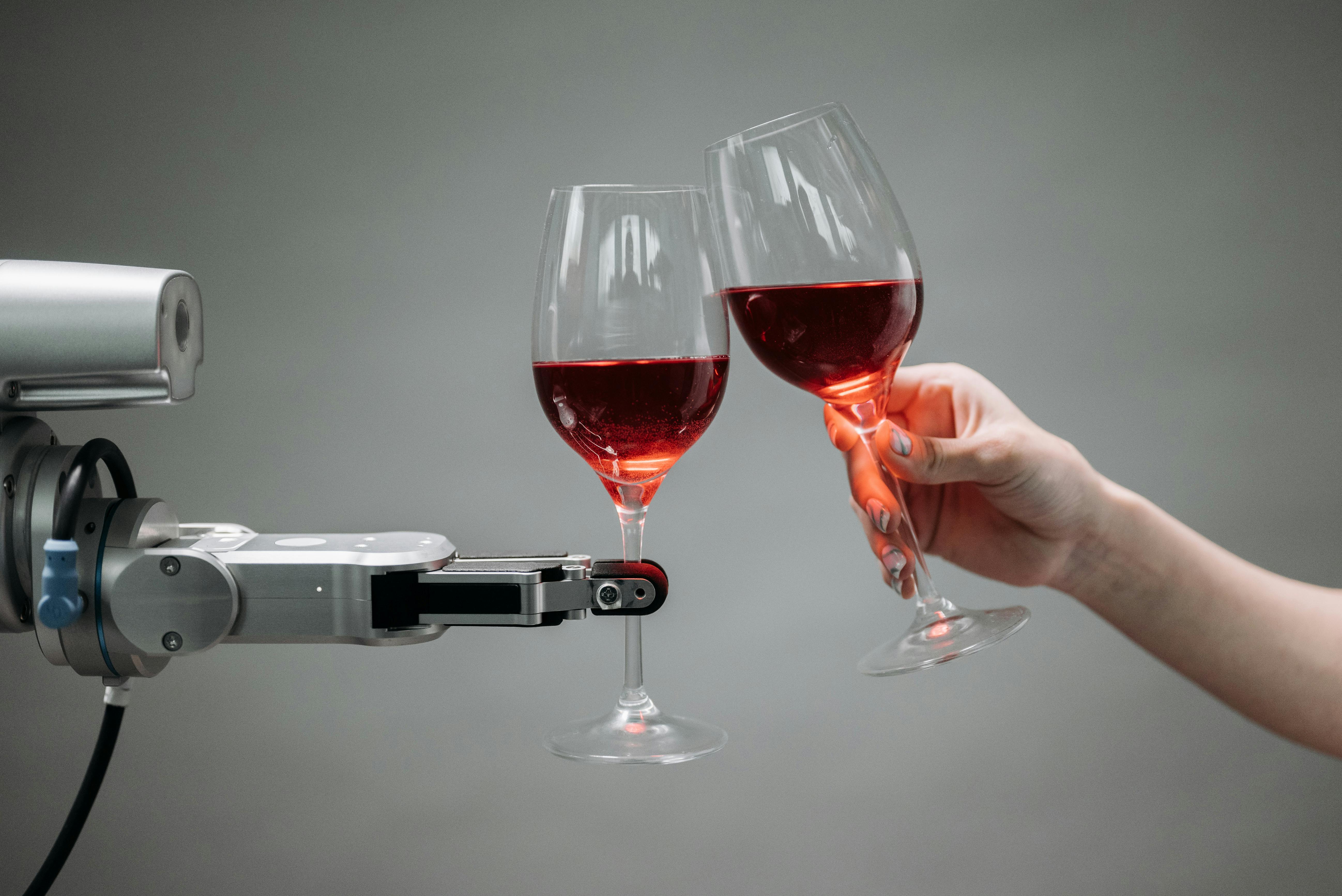 A robot and man holding wine glasses and sharing a toast