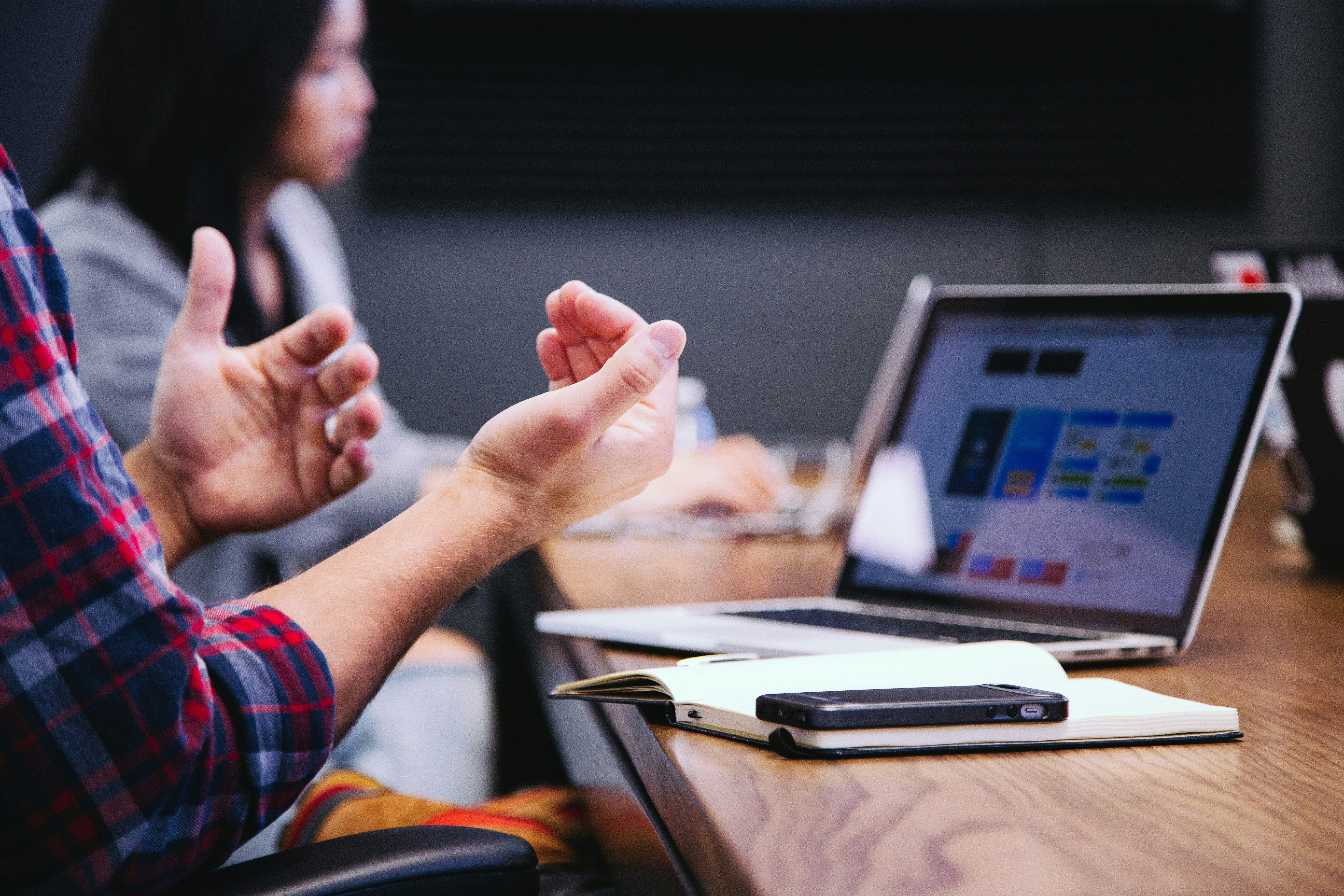 Main Image: Microsoft computer while someone explains something in a meeting