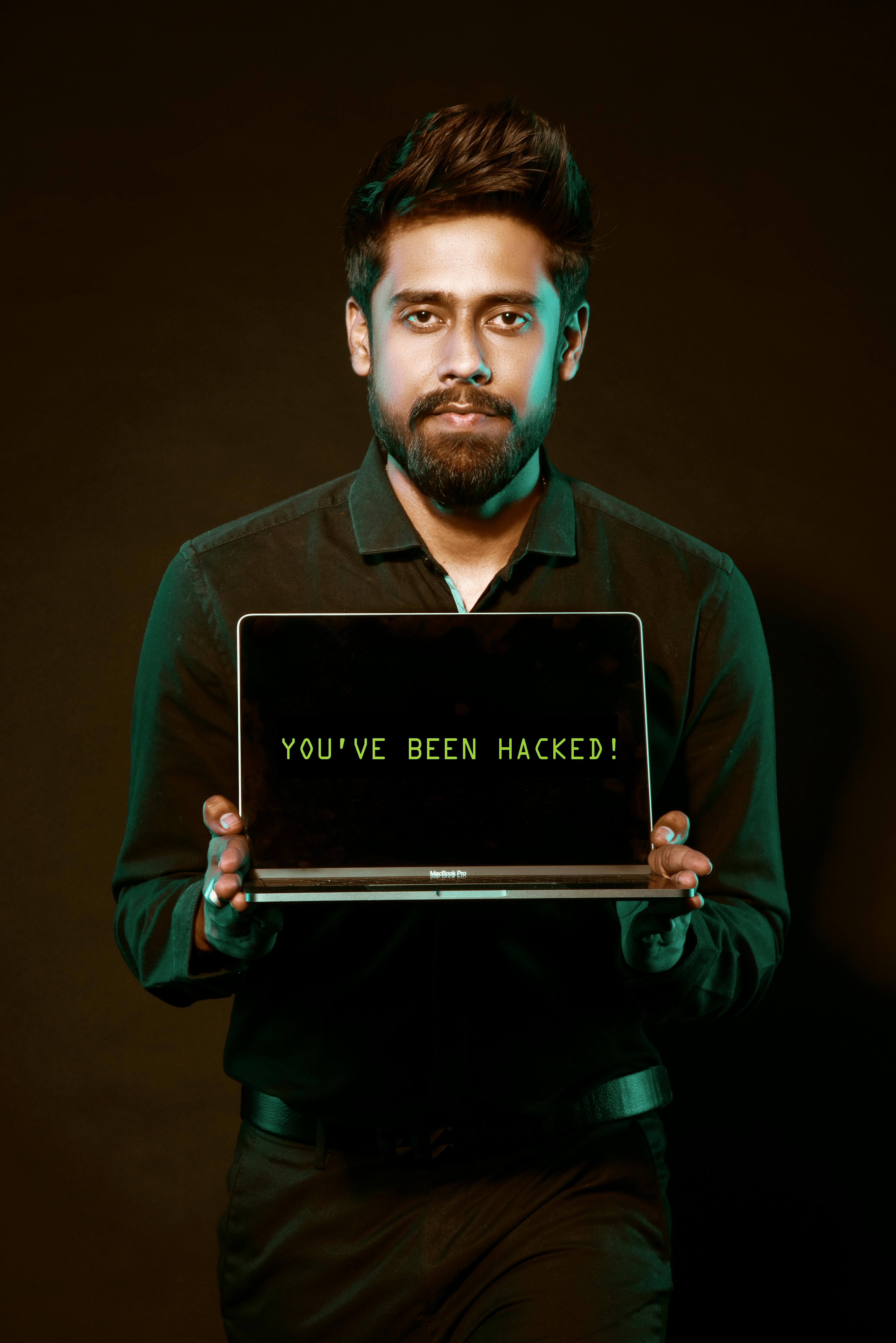 Man holding laptop demonstrating a hacked computer