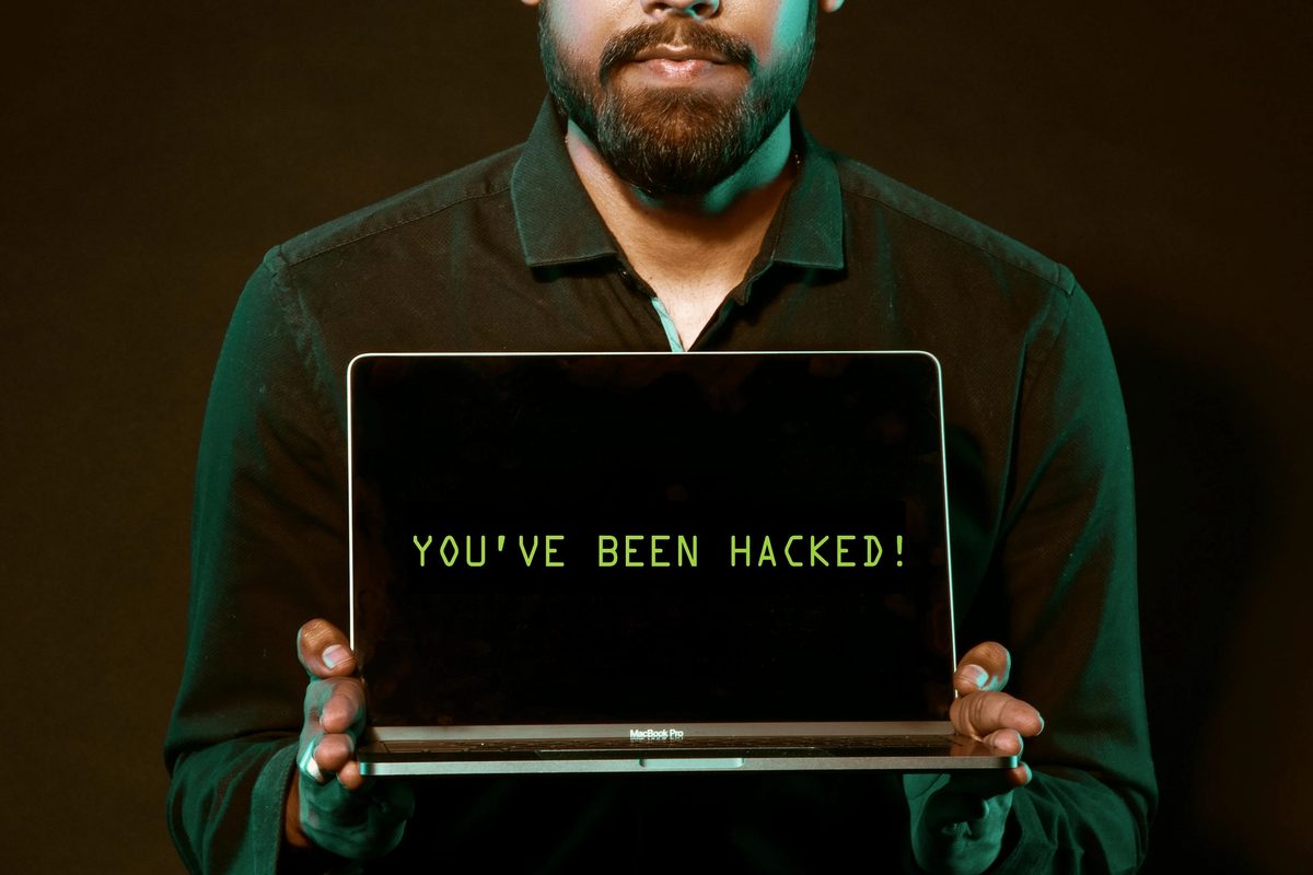 Man holding laptop demonstrating a hacked computer