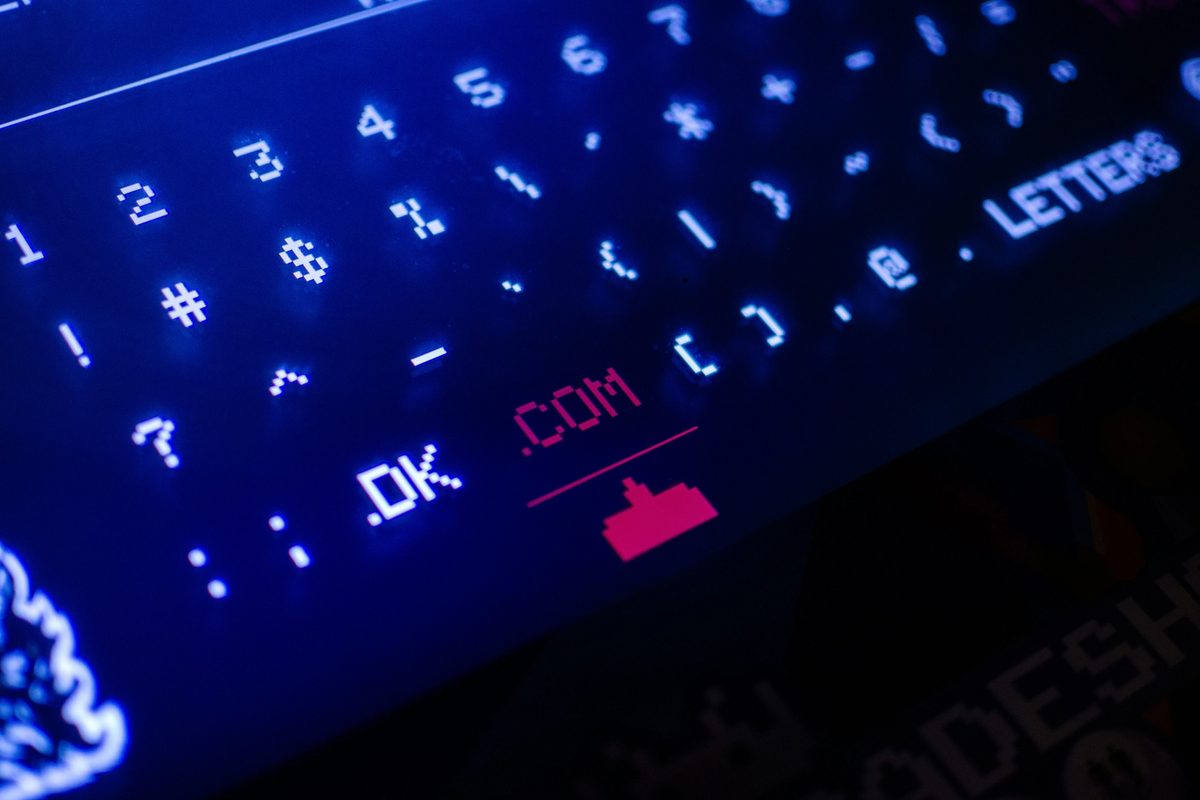A black and blue computer keyboard with a '.com' key highlighted
