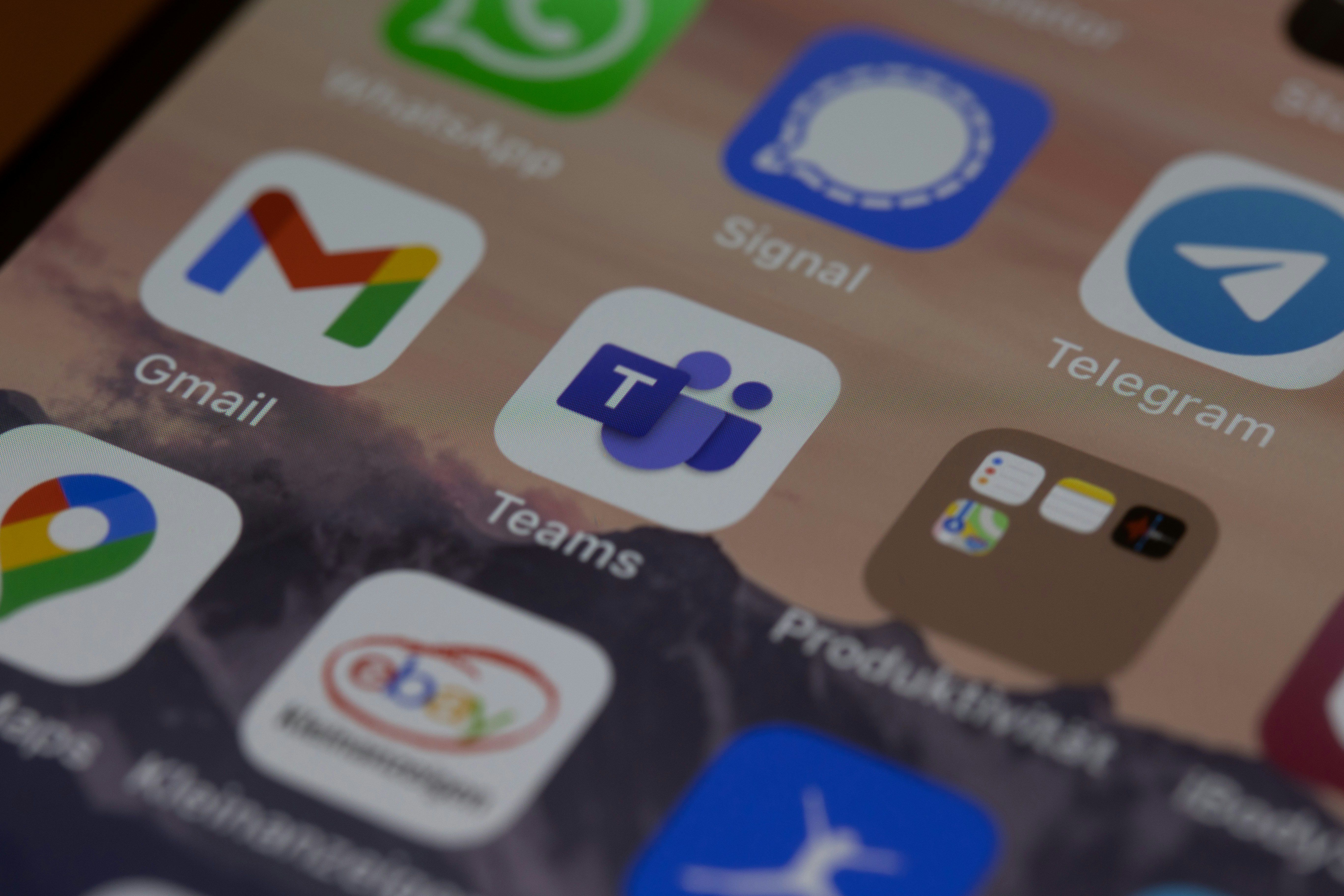 iPhone homescreen with various app icons including Microsoft Teams