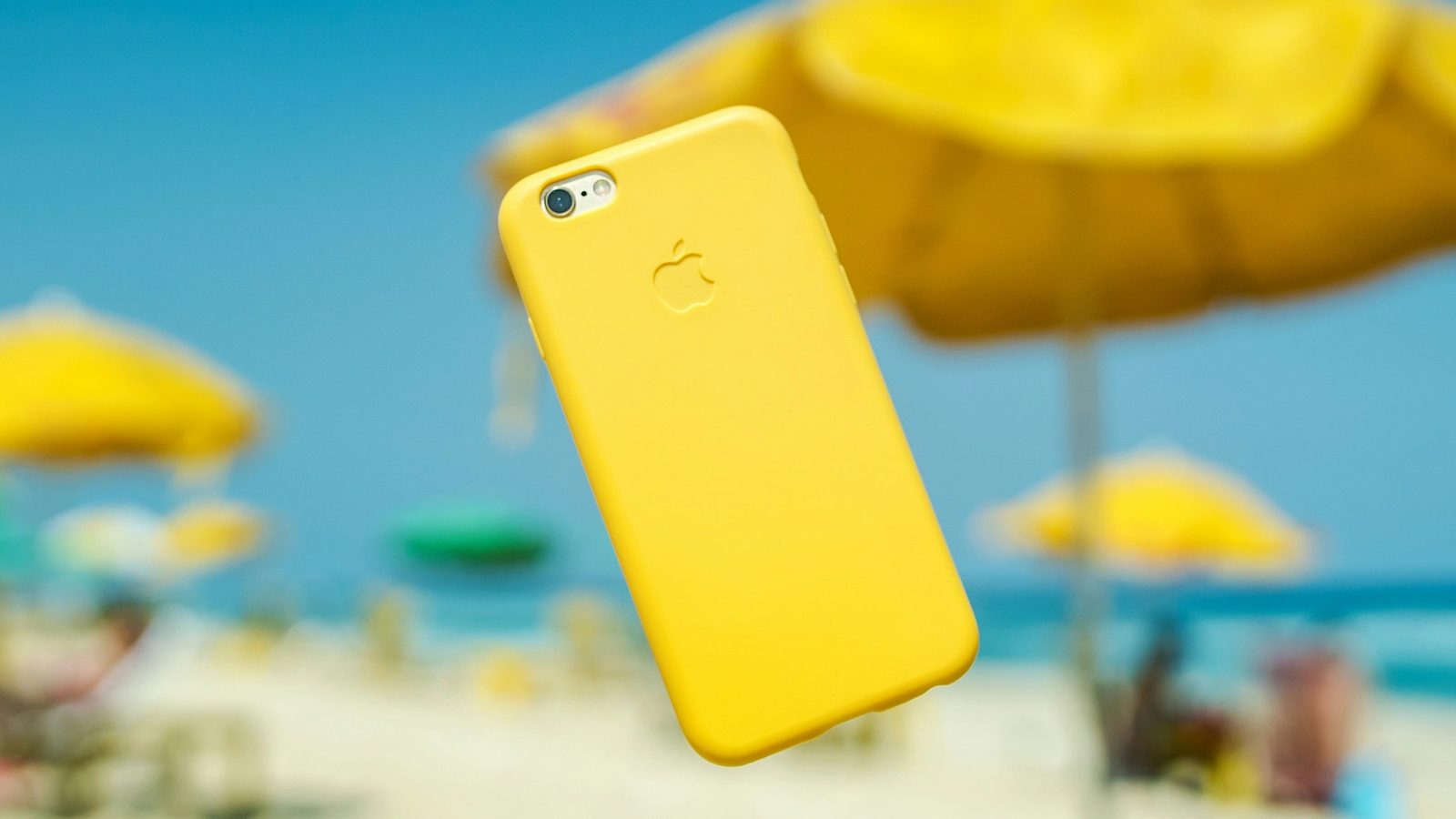 Main Image: iPhone with a yellow cover suspended in the air at Rio beach