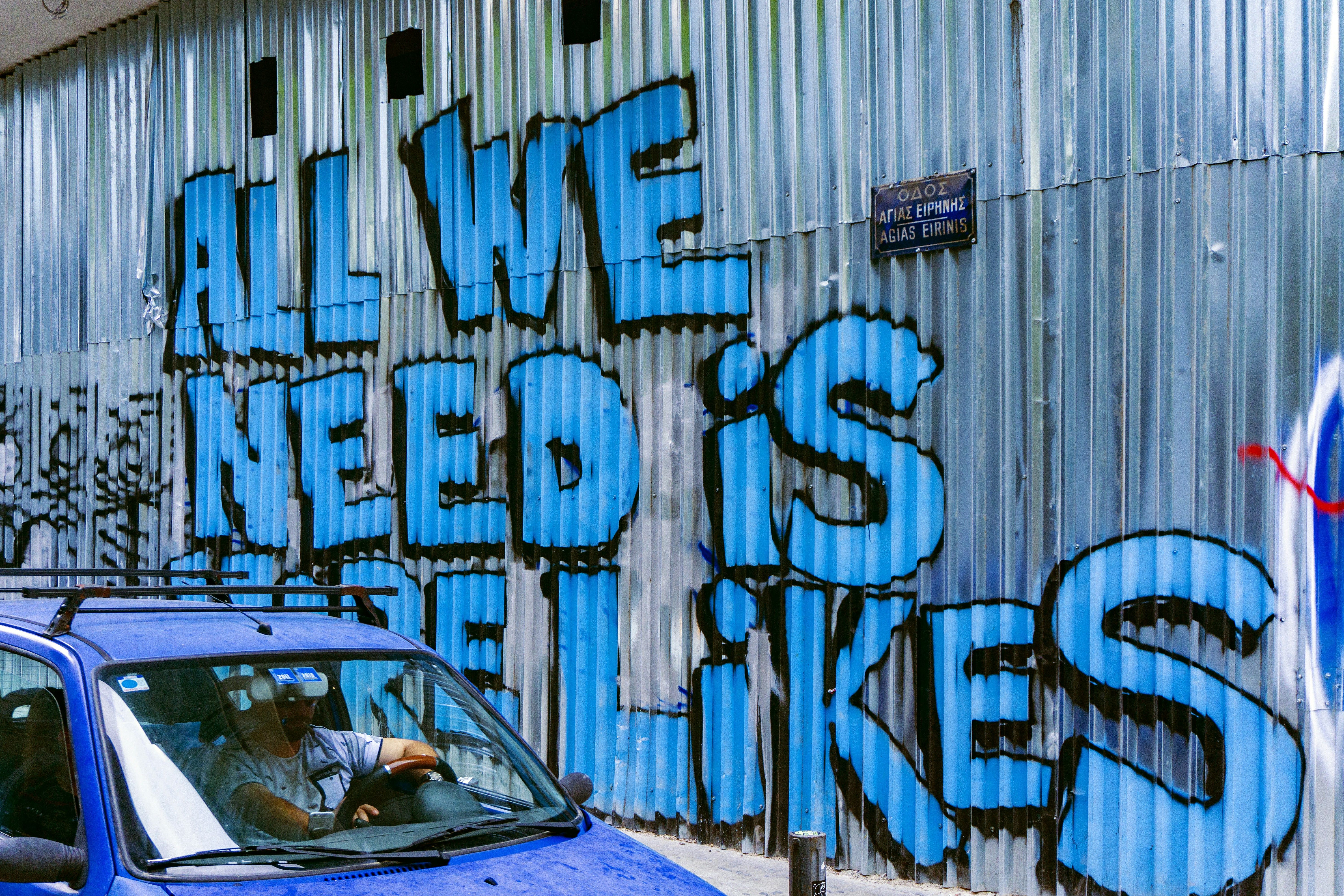 Graffiti on a wall that reads " All We Need Is More Likes"