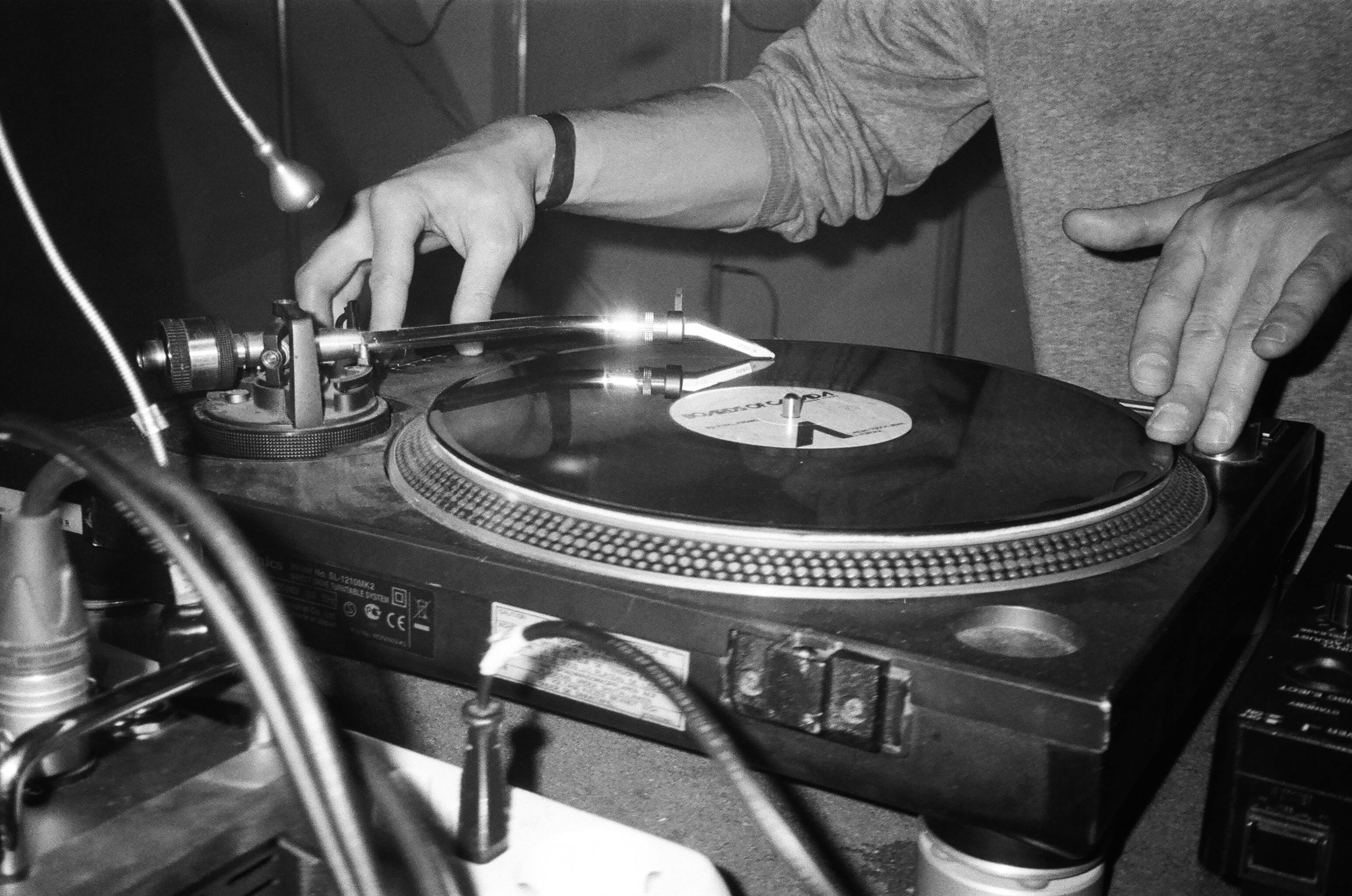 Grayscale photo of someone playing the turntables