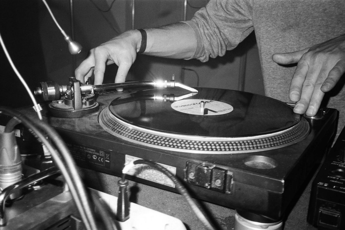 Grayscale photo of someone playing the turntables
