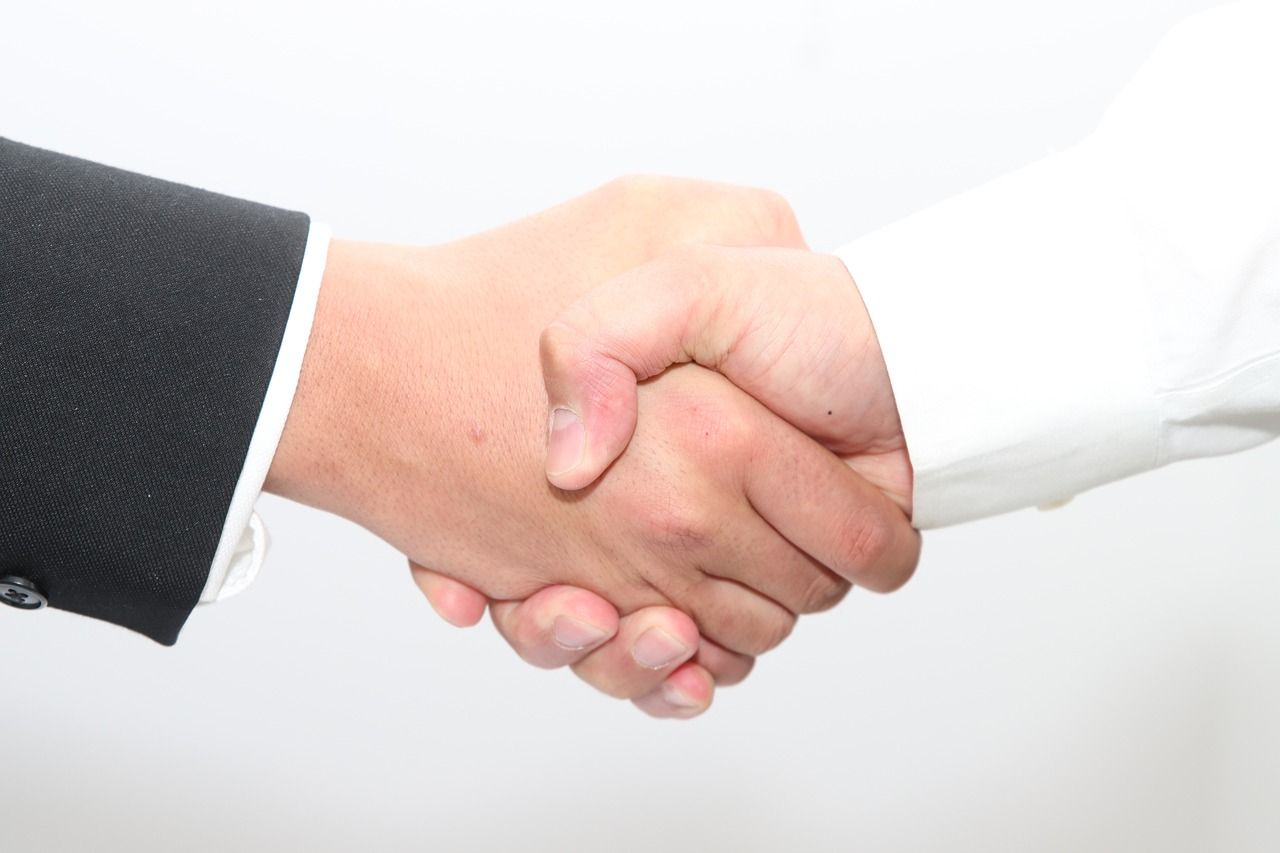 Handshake between two individuals symbolizing Canva and Affinity