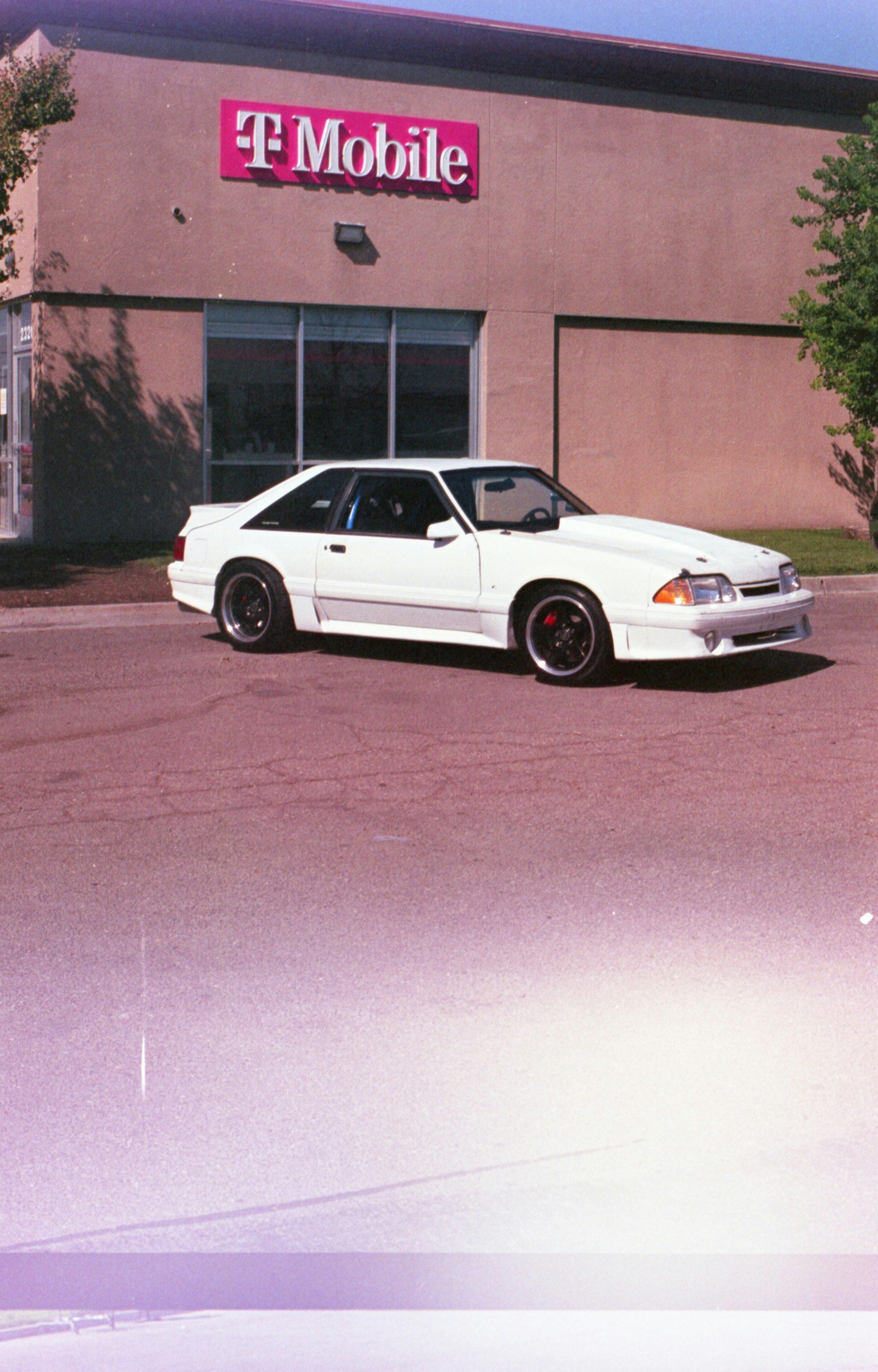 White car parked outside a T-Mobile retail store