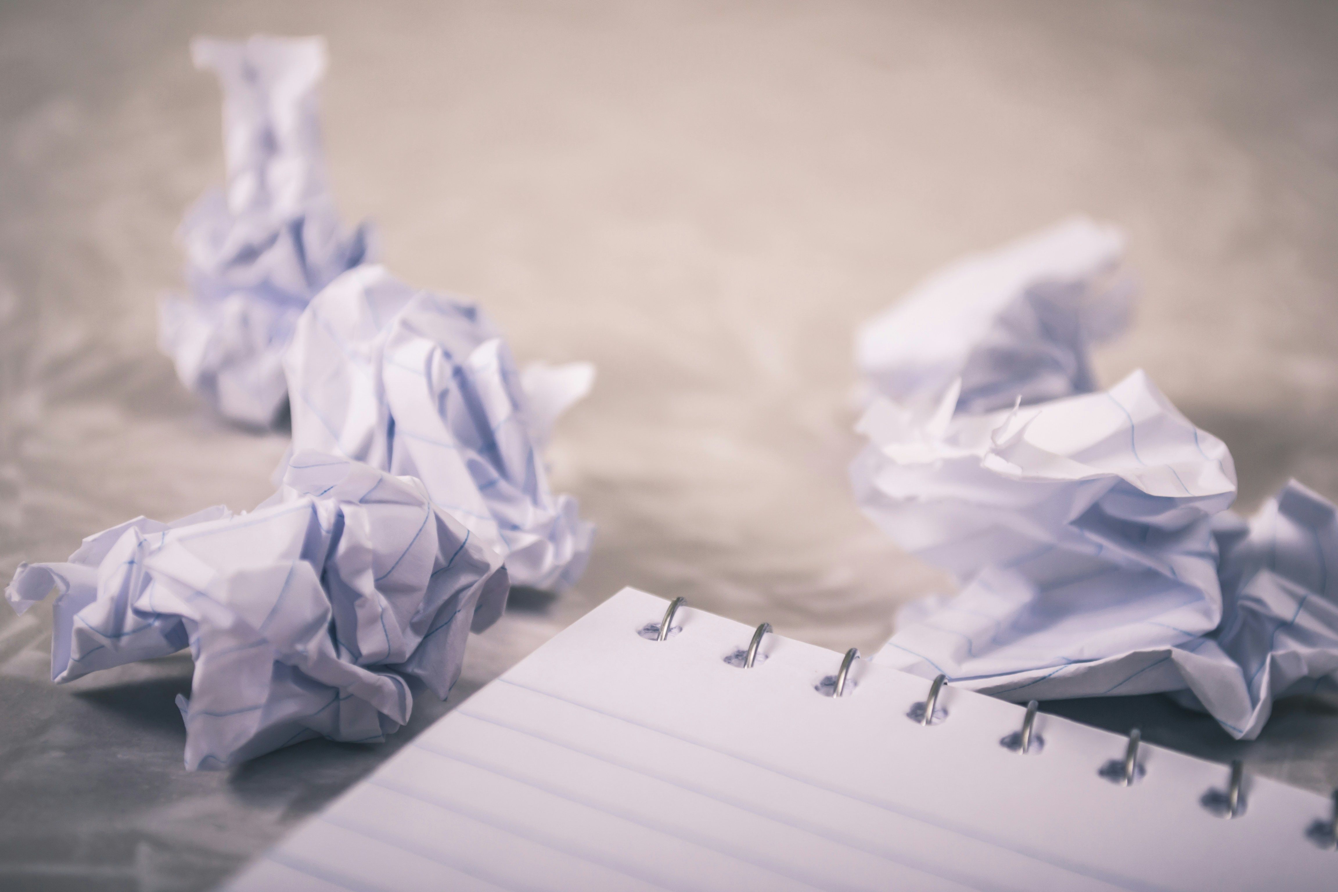 Crumpled paper next to a note pad. Demonstrating writer's block.
