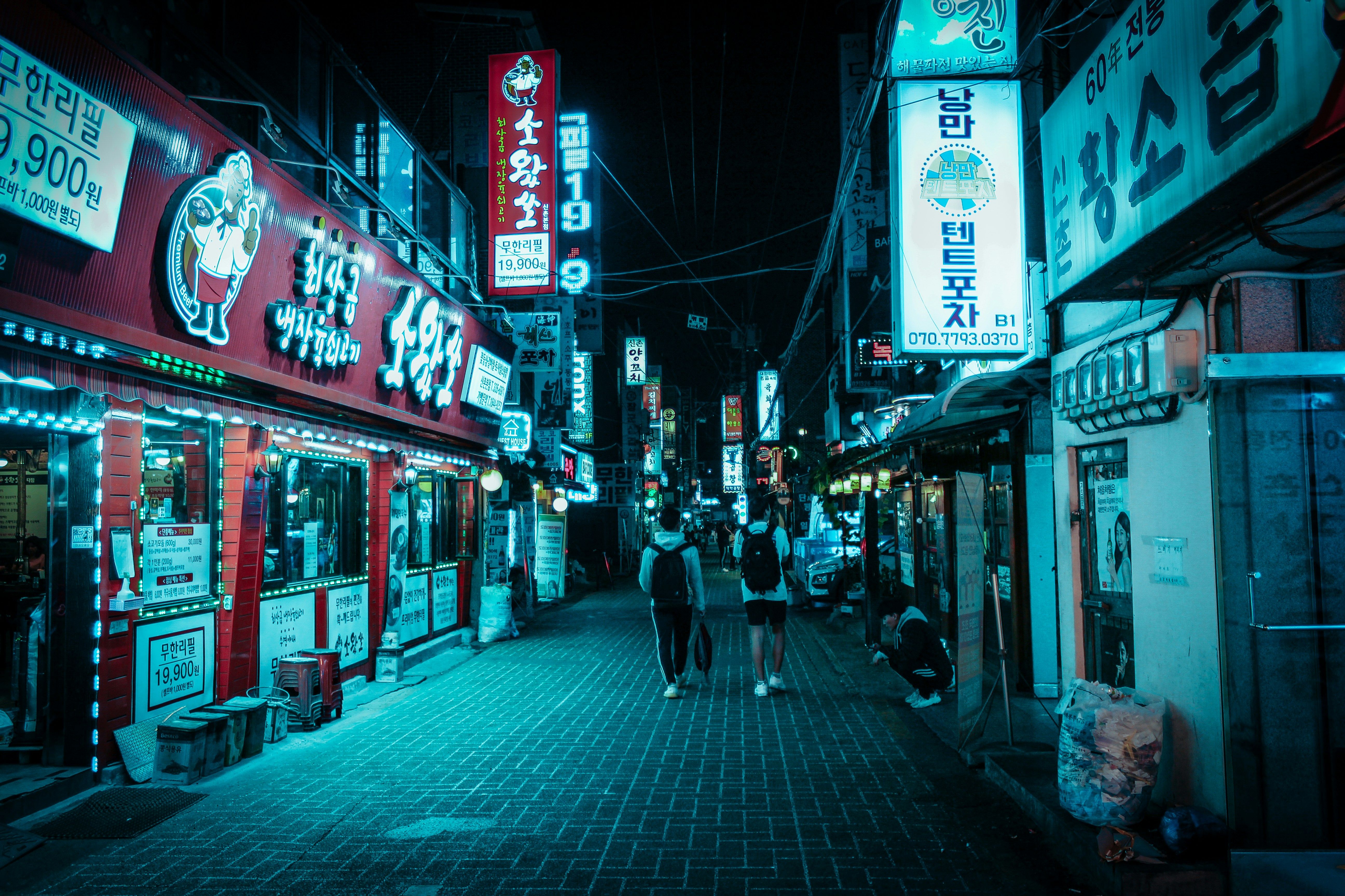 People walking down a Seoul street at night