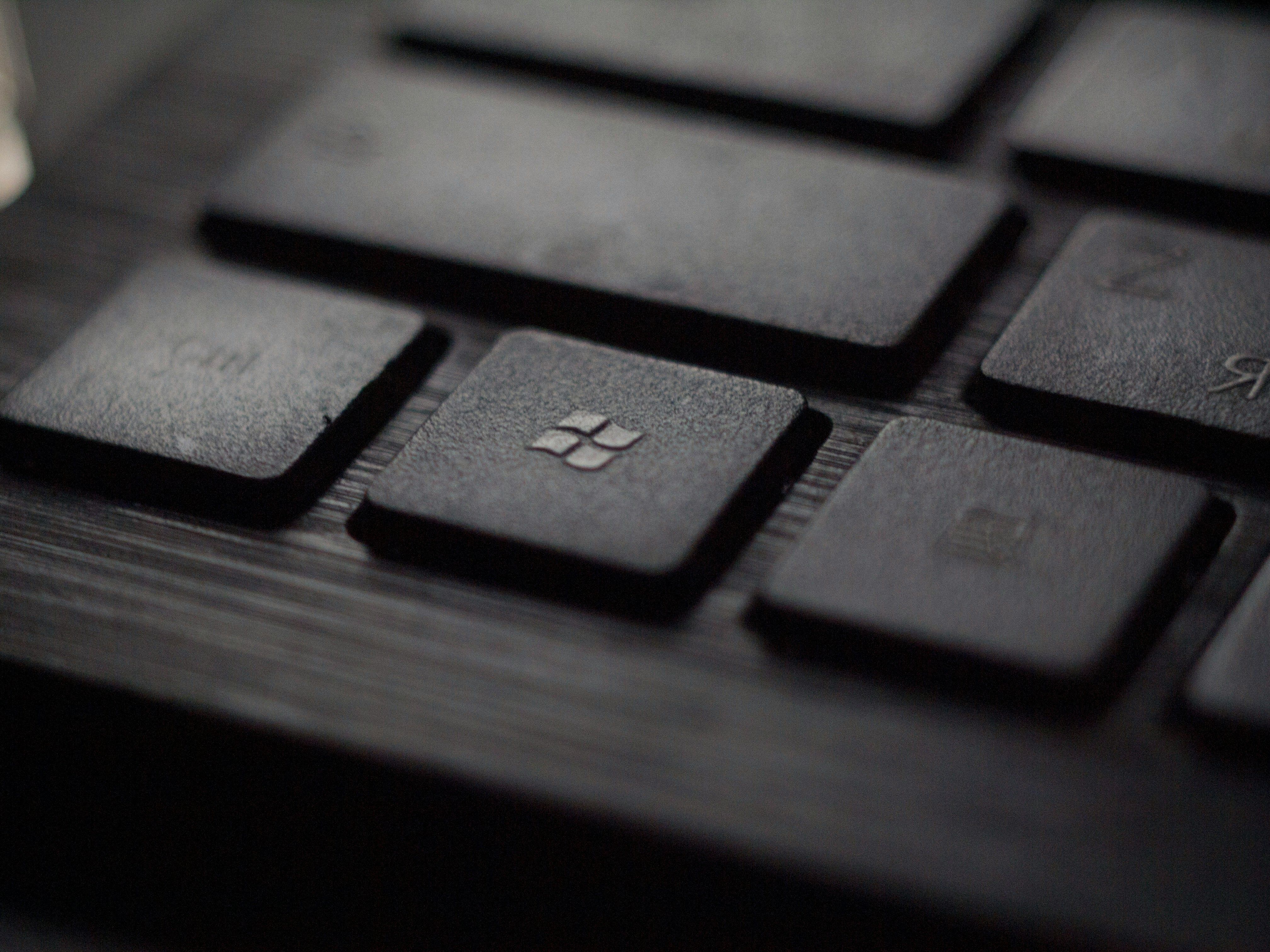 Black laptop computer keyboard in closeup photo with Microsoft logo visible