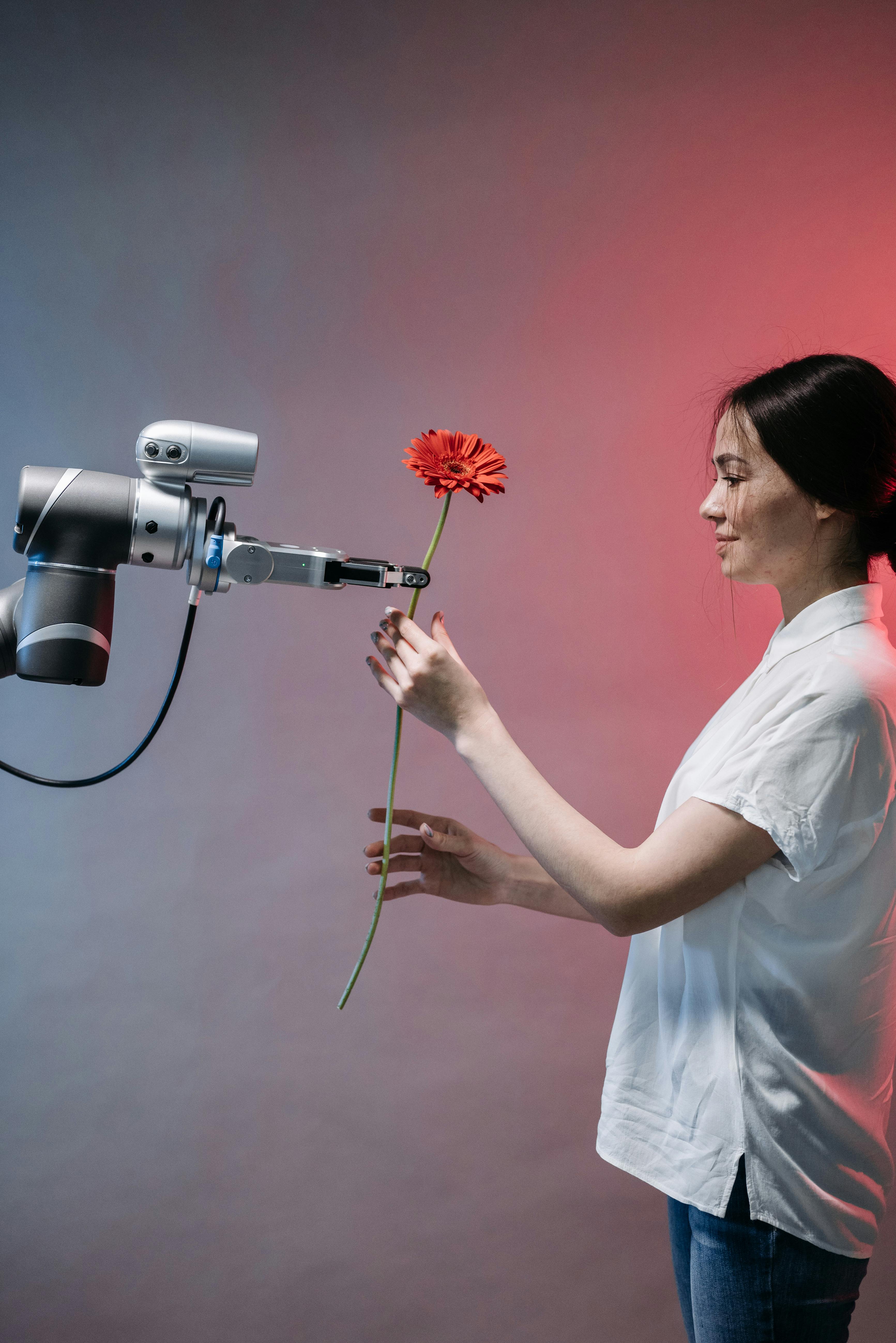 A robot passing a flower to a lady