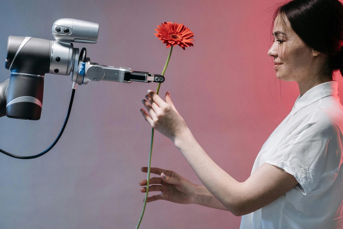 A robot passing a flower to a lady