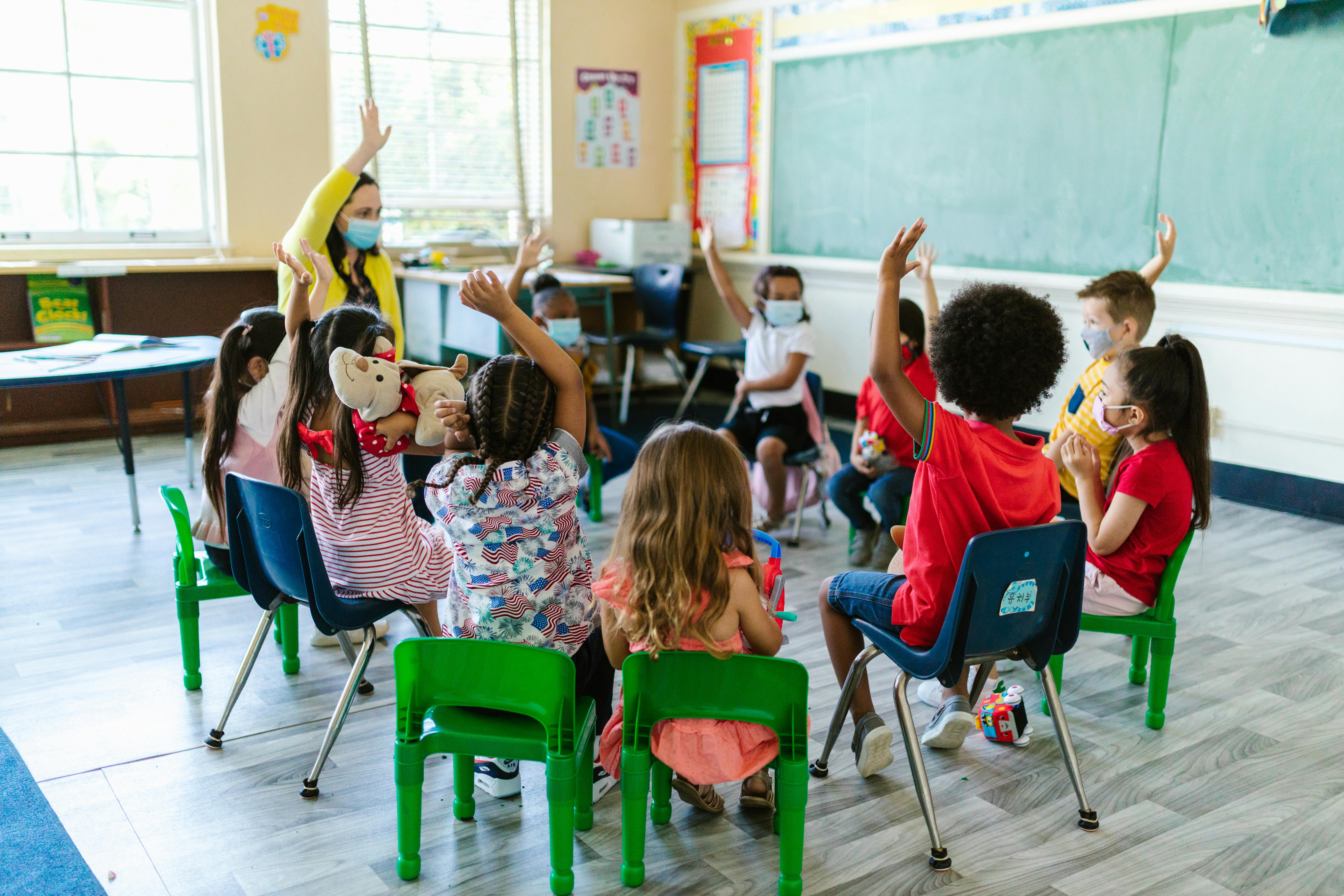 School kids and their teacher sat in a circle