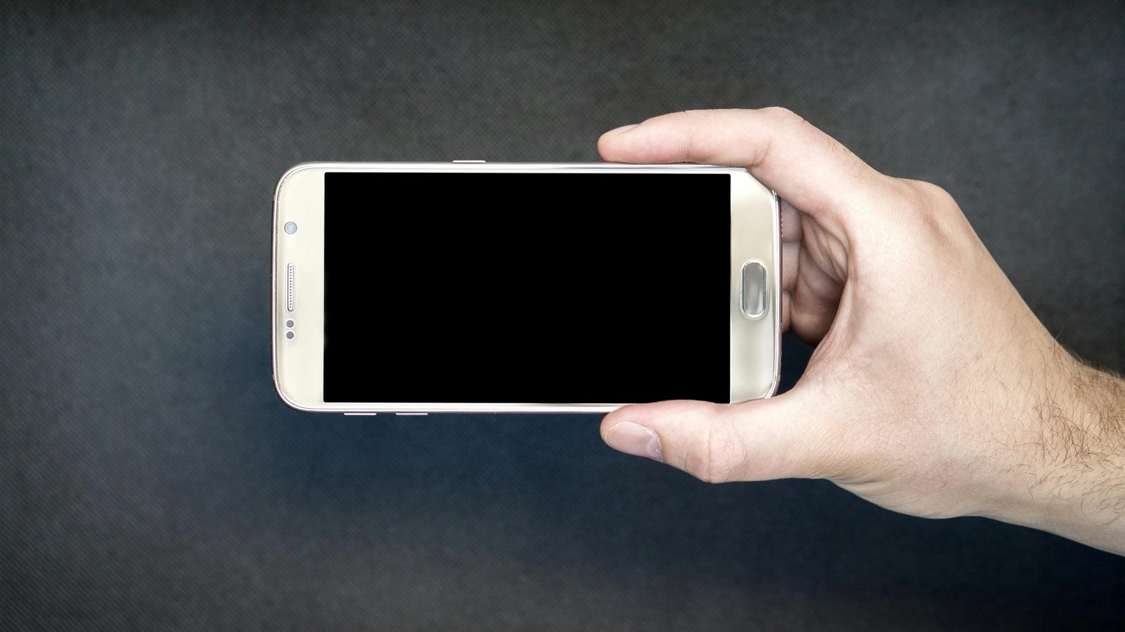 Main image. Hand holding an iPhone