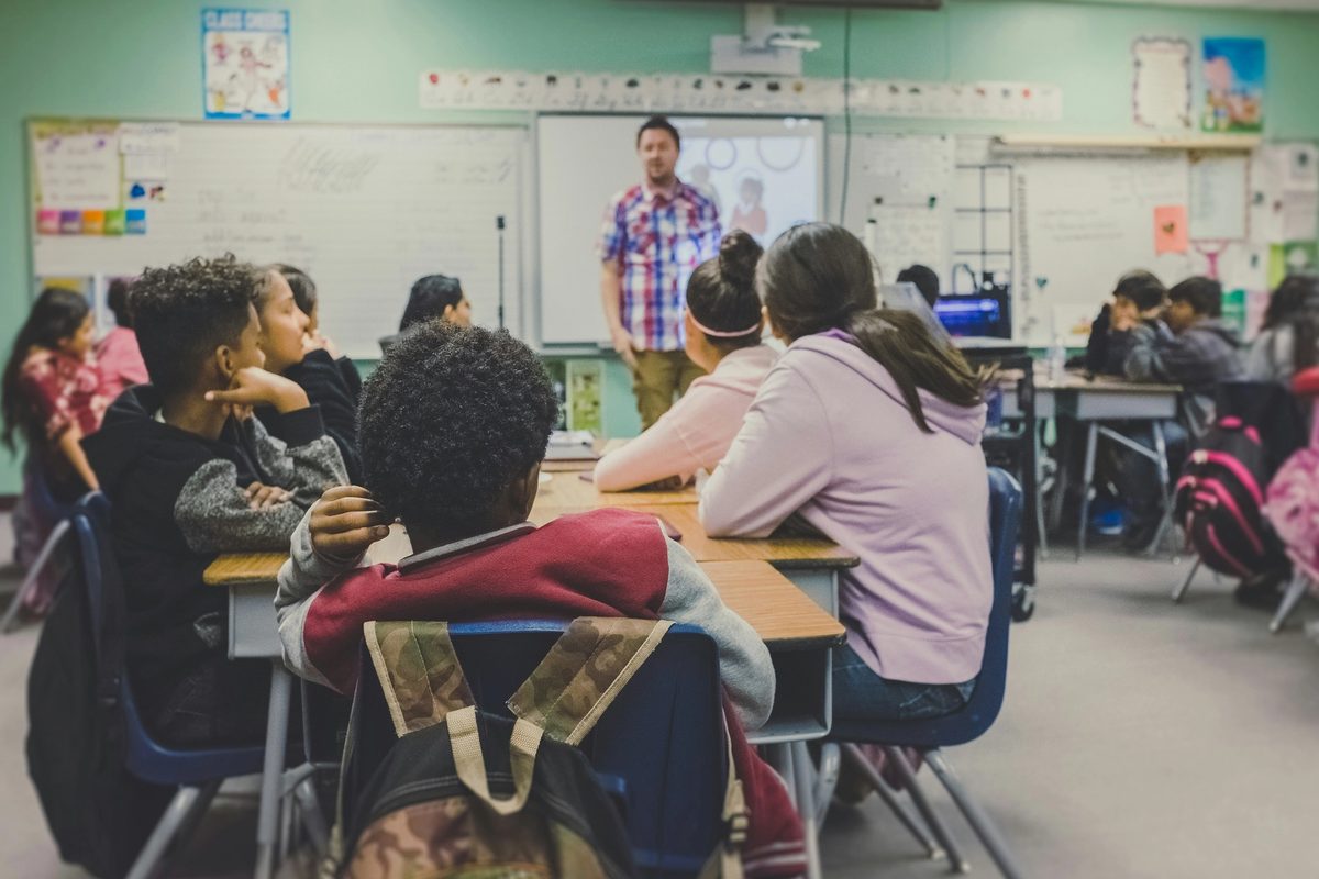 A classroom of students listening to their teacher.