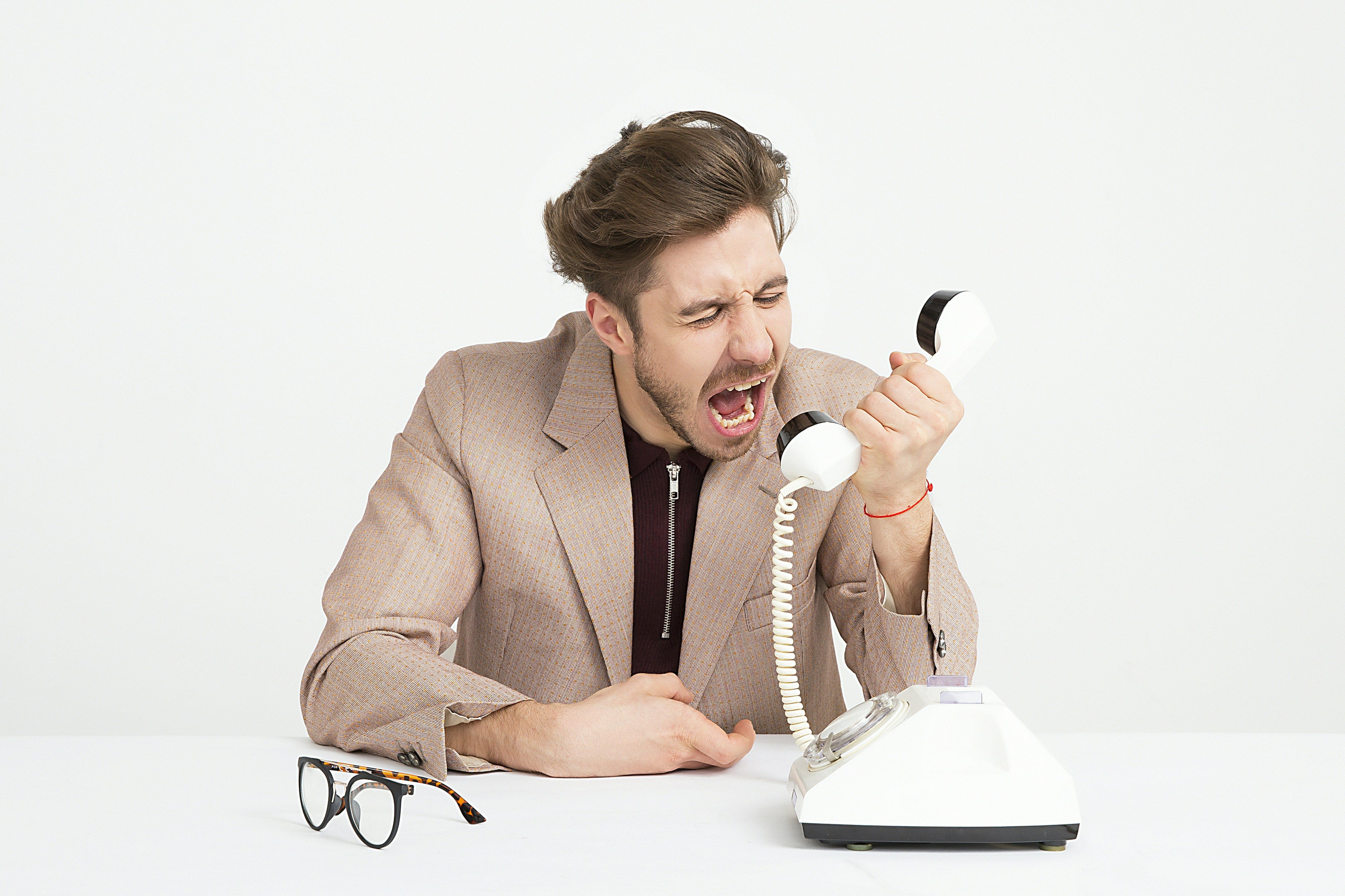 A man screaming at a telephone.