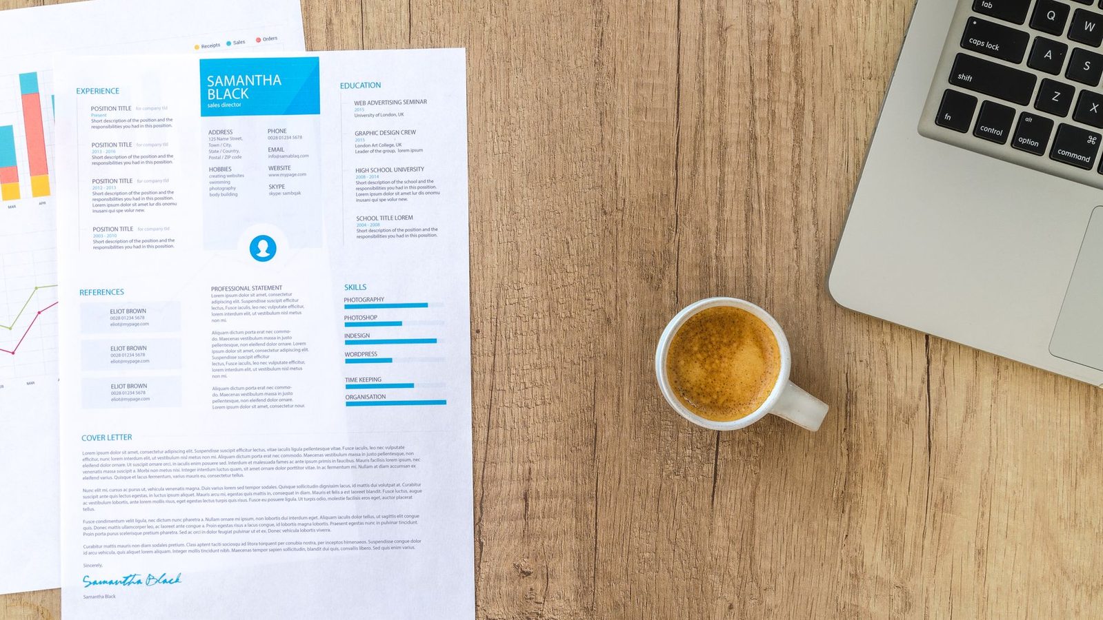 A resume beside a laptop on a desk