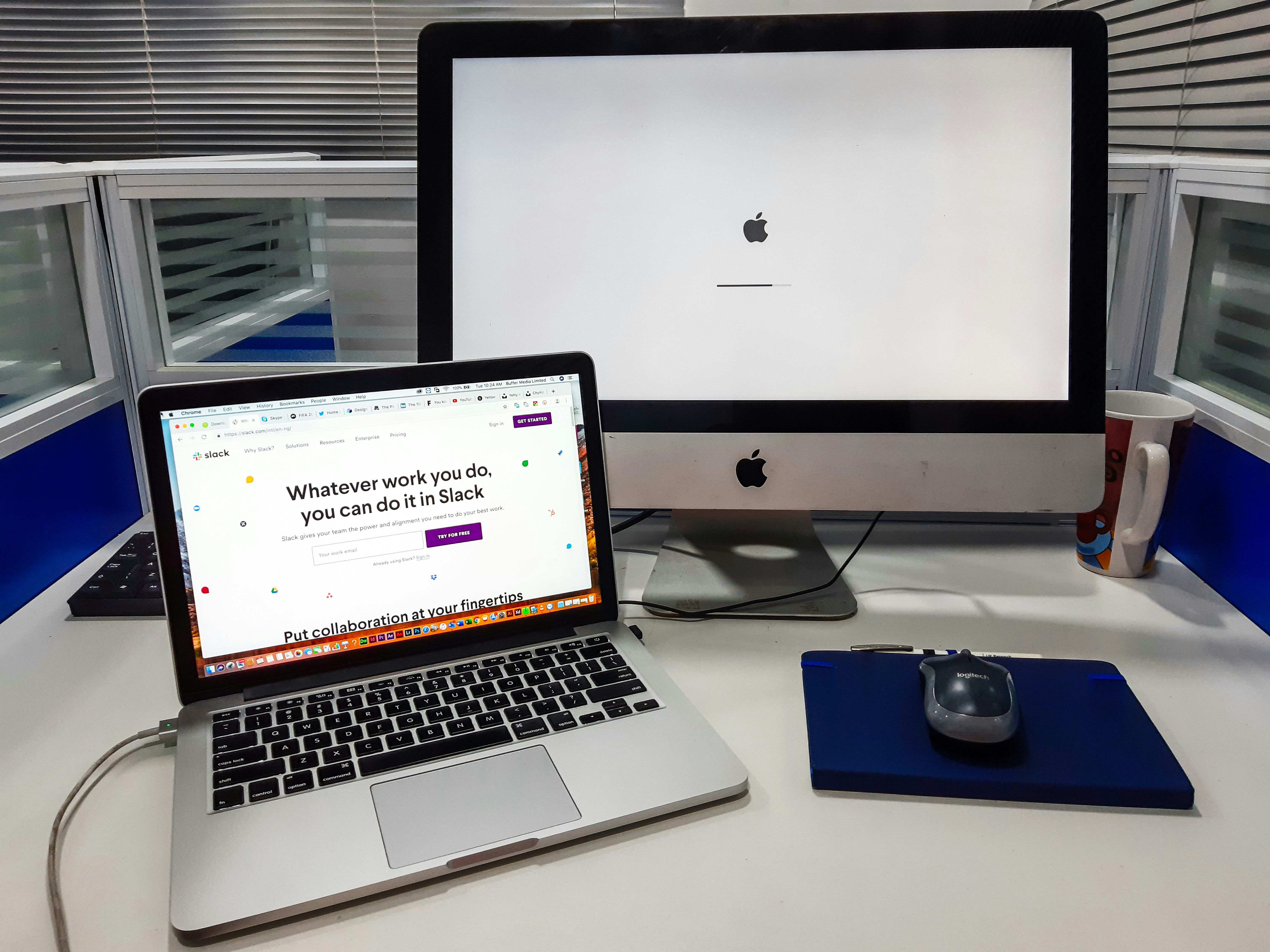 An iMac next to a MacBook Pro on a work station