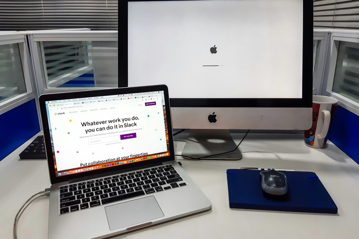 An iMac next to a MacBook Pro on a work station