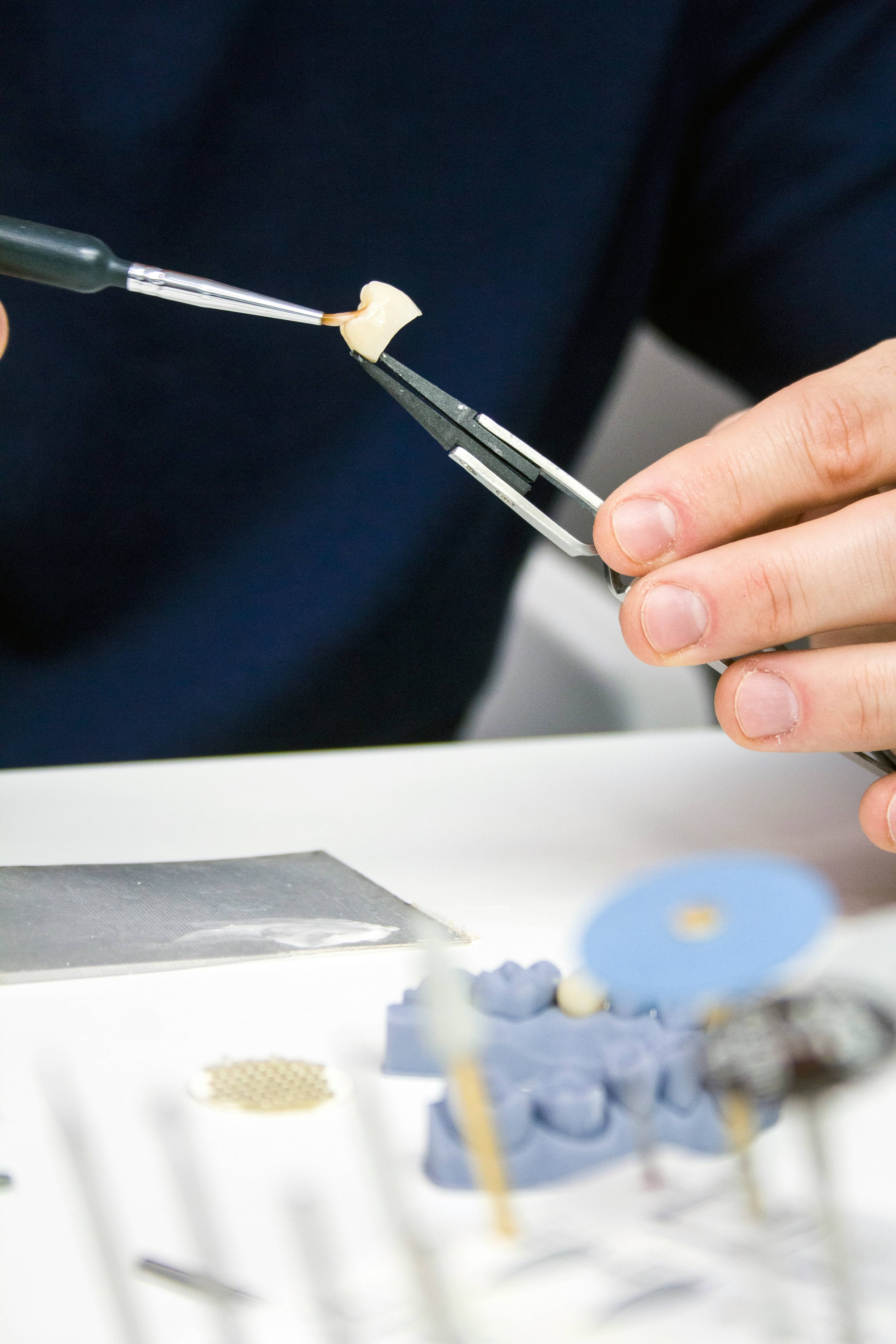 A dentist using tools to manipulate a dental crown