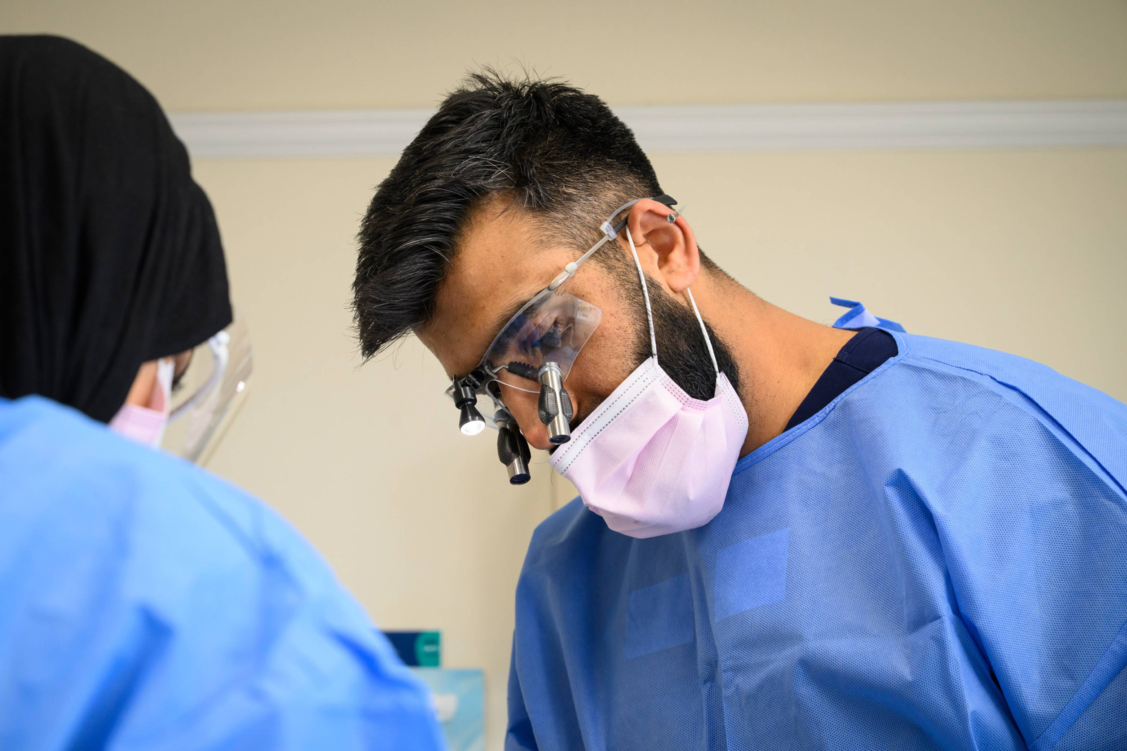 Ahmer Imtiaz inspecting a patient's teeth