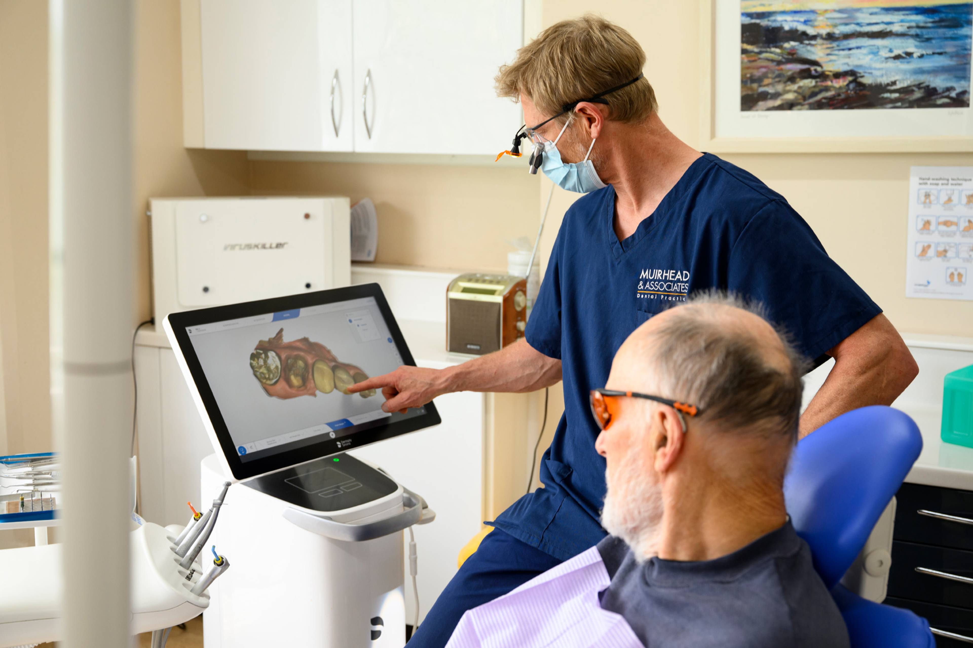 Rob Muirhead showing a patient a scan of his teeth