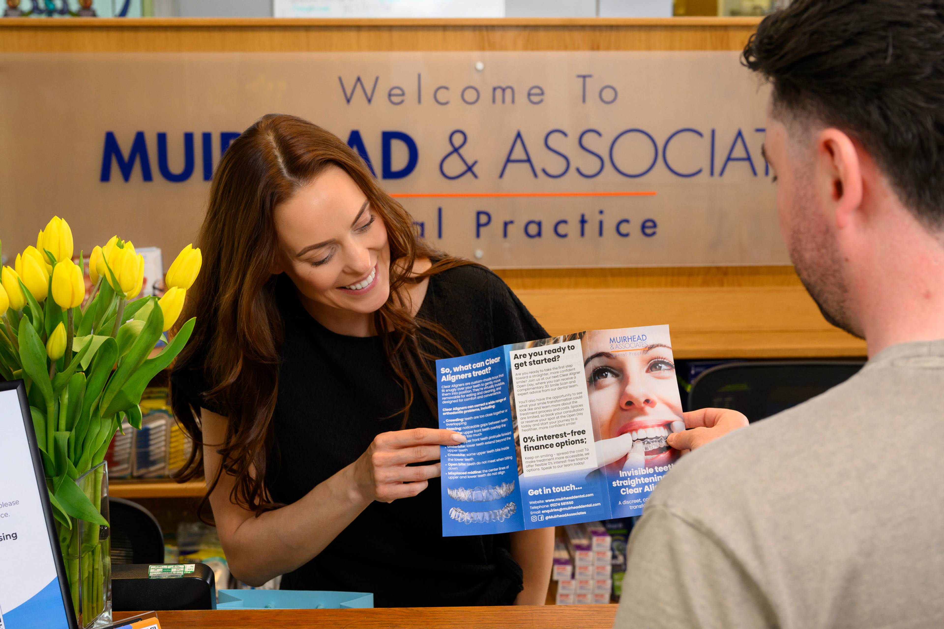 Our practice manager showing a clear aligners leafleft to a patient