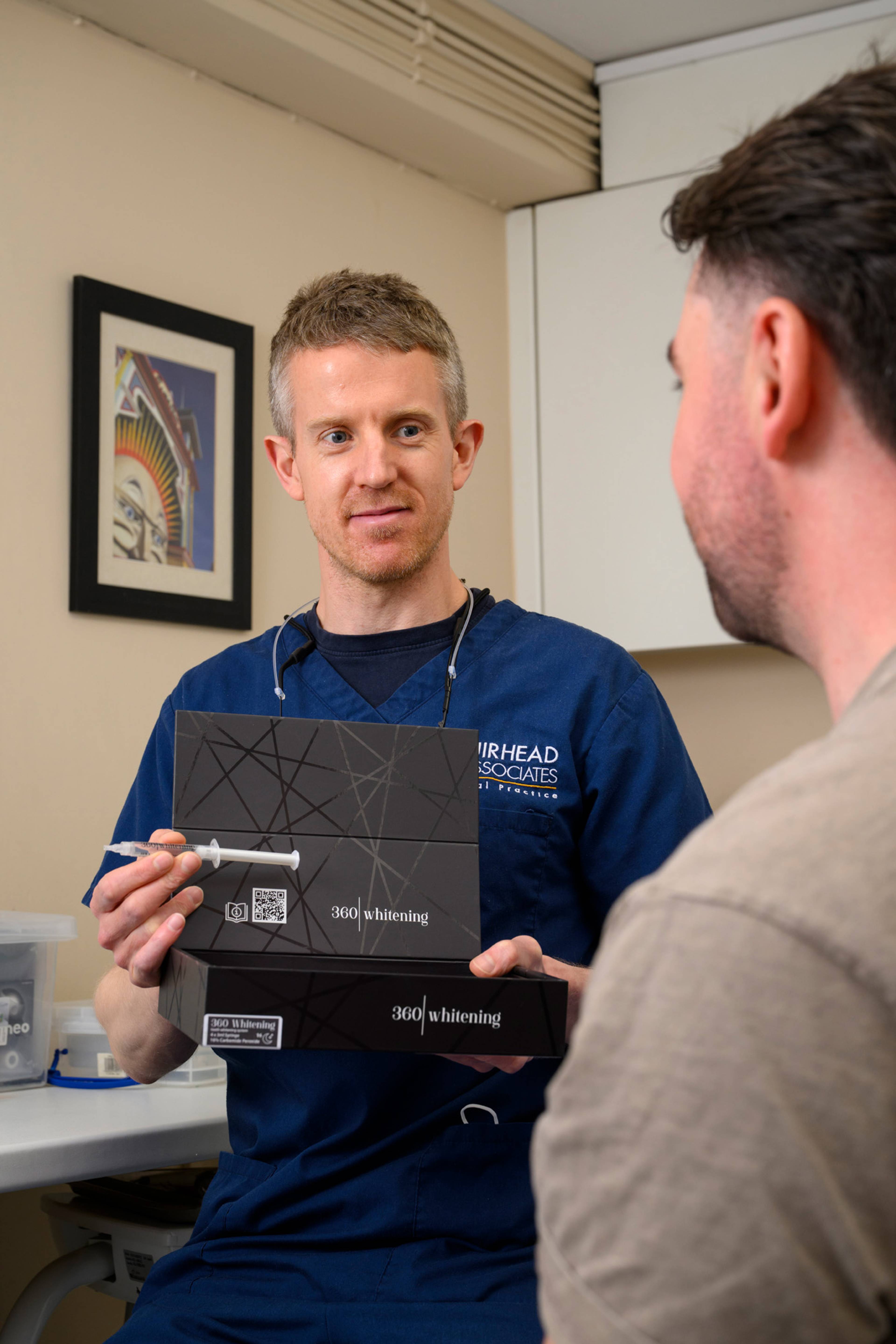 One of our dentists shows a patient the 360 whitening kit