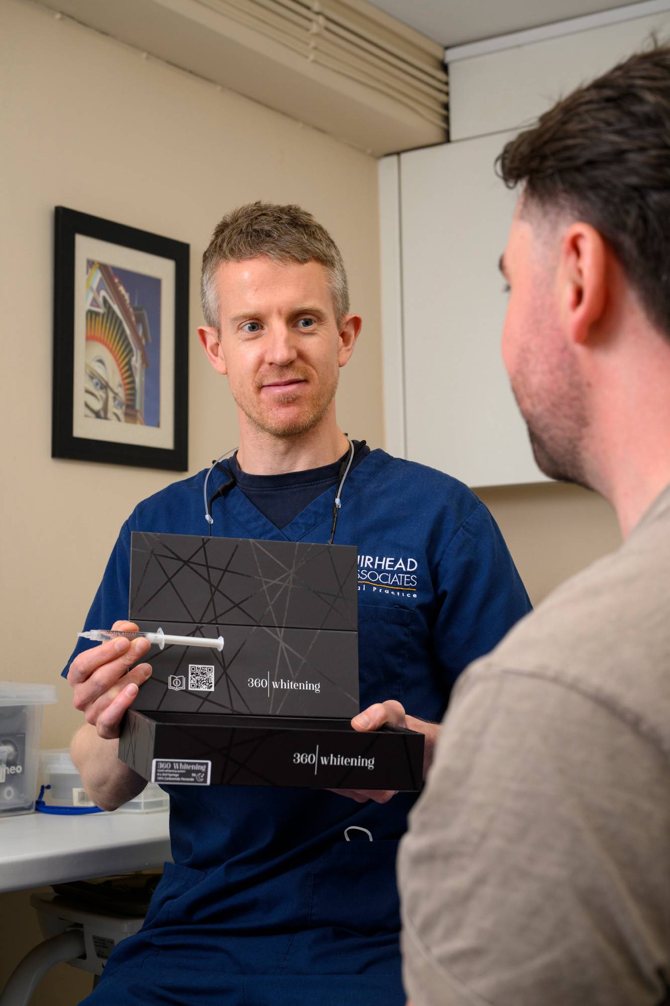 One of our dentists shows a patient the 360 whitening kit