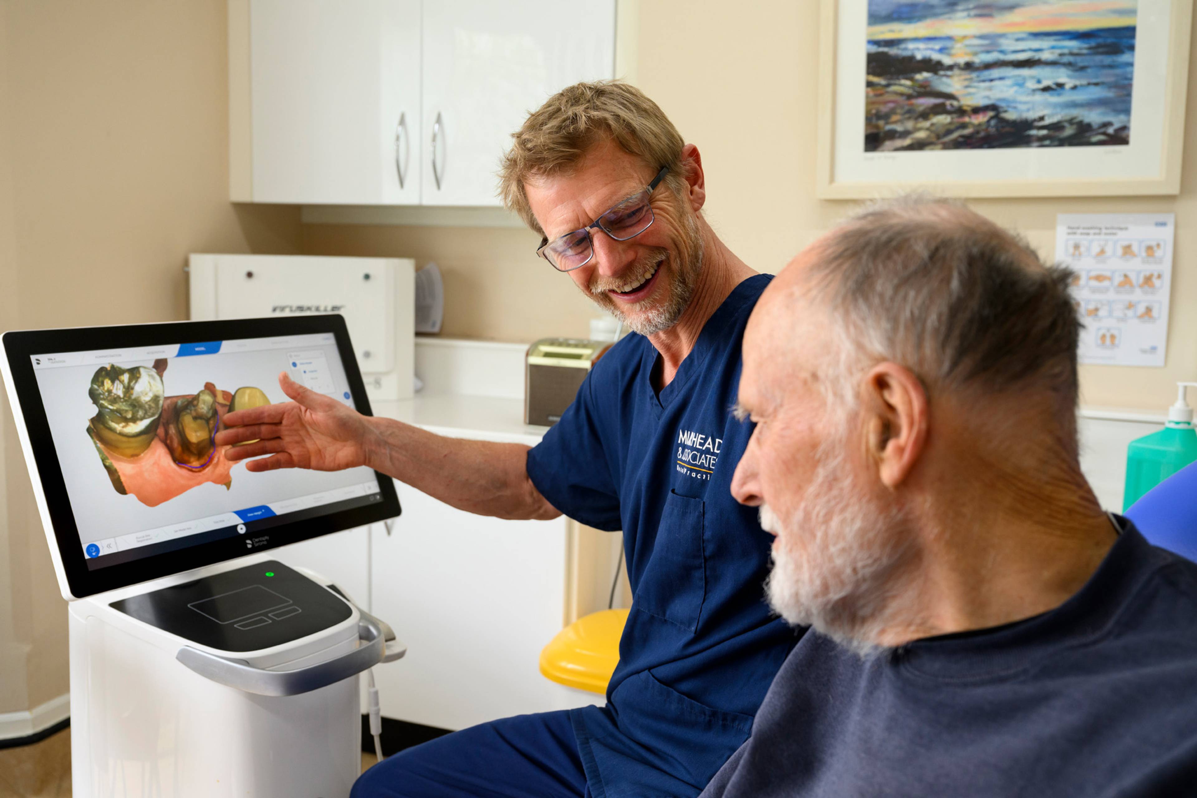 Robert Muirhead showing a patient one of his dental scans