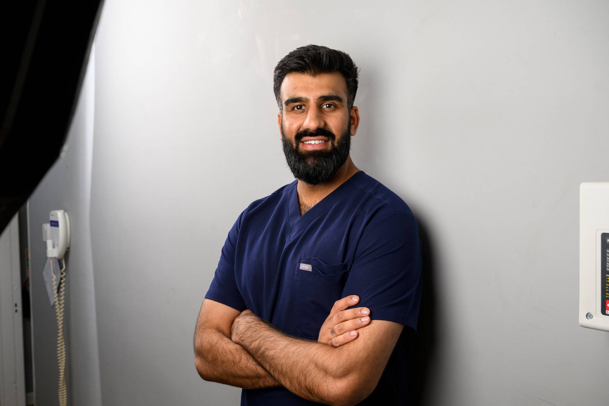 Ahmed Imtiaz standing with his arms folded and smiling