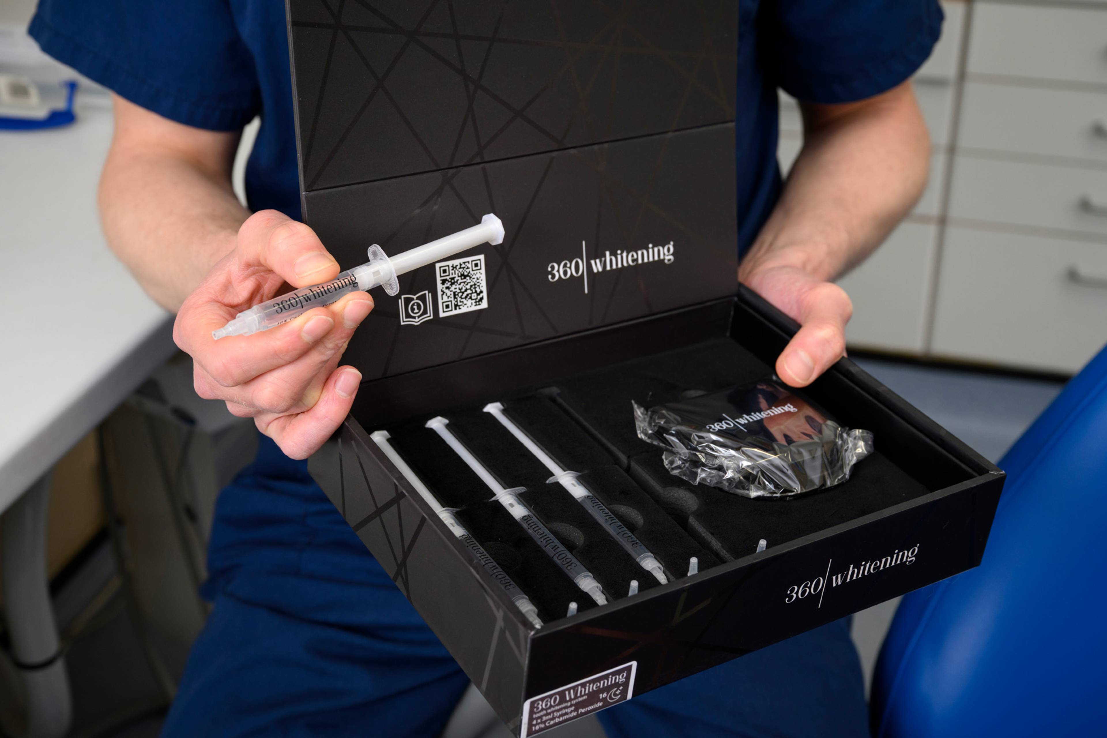 One of our dentists demonstrates the 360 whitening system with a syringe of whitening gel in his hand