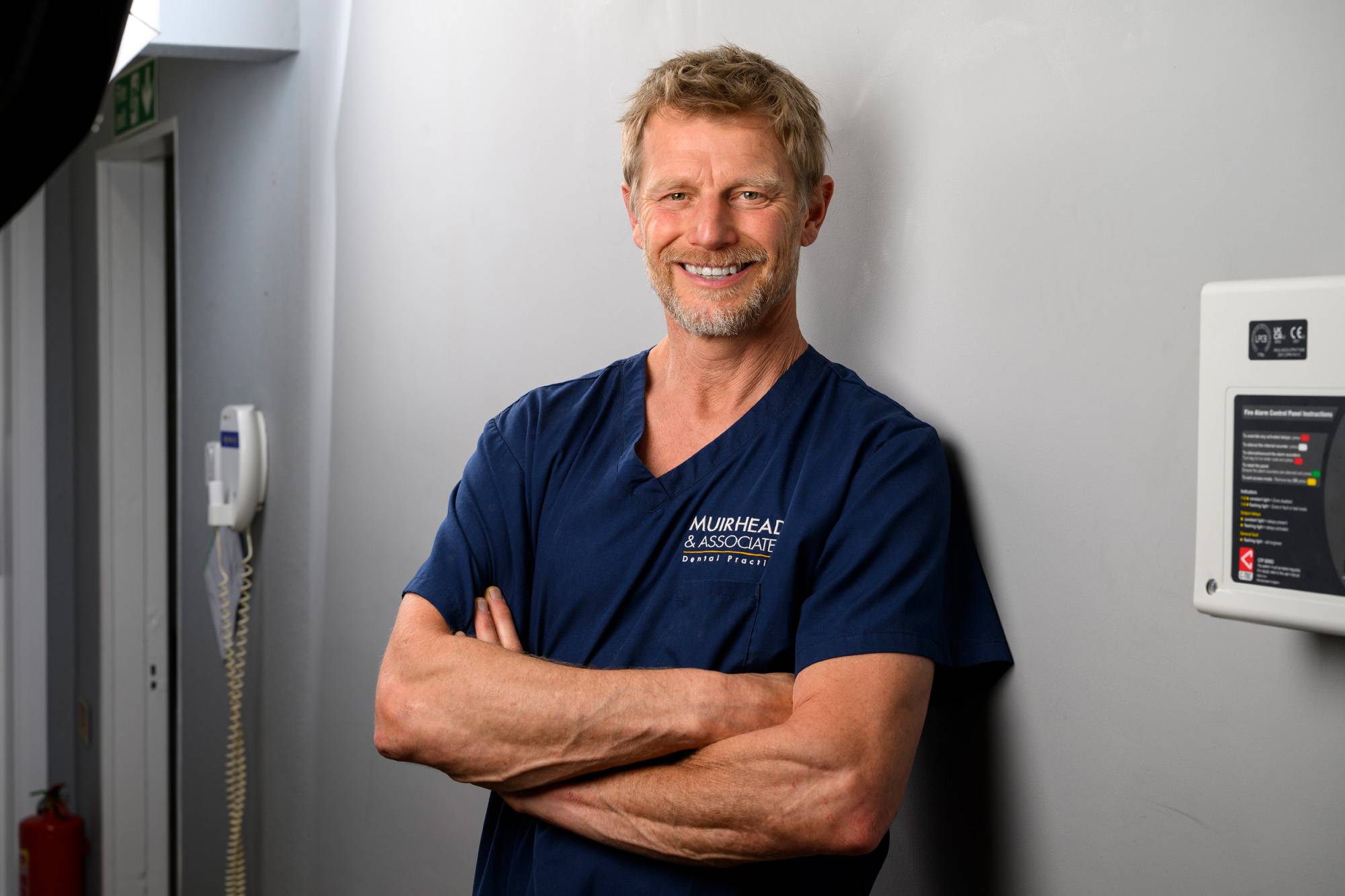 Robert Muirhead standing with his arms folded in one of the treatment rooms