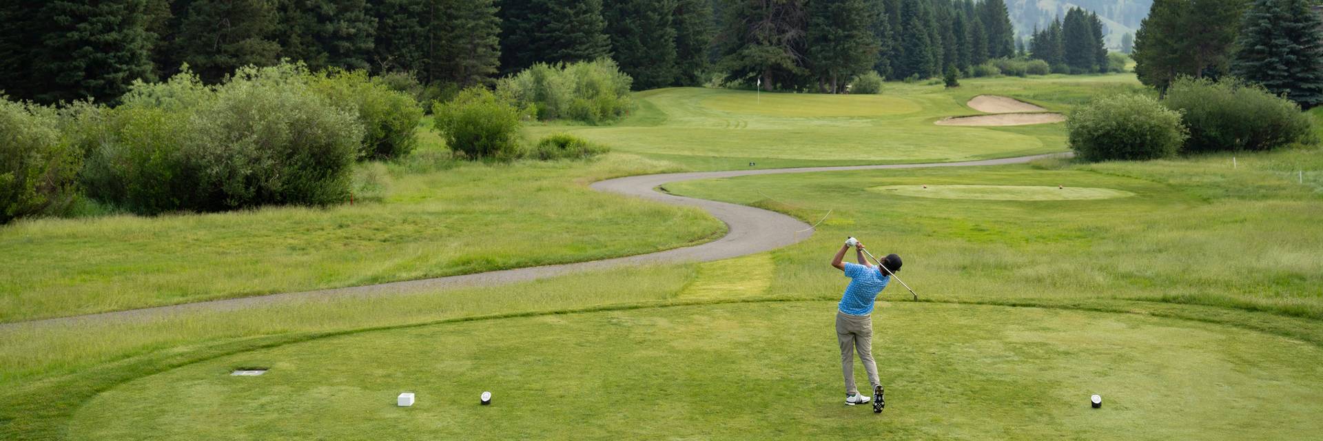 Golfer teeing off at the Big Sky Resort Golf Course