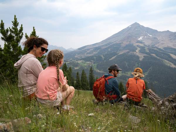 Family sitting in grass with Lone Peak in the background