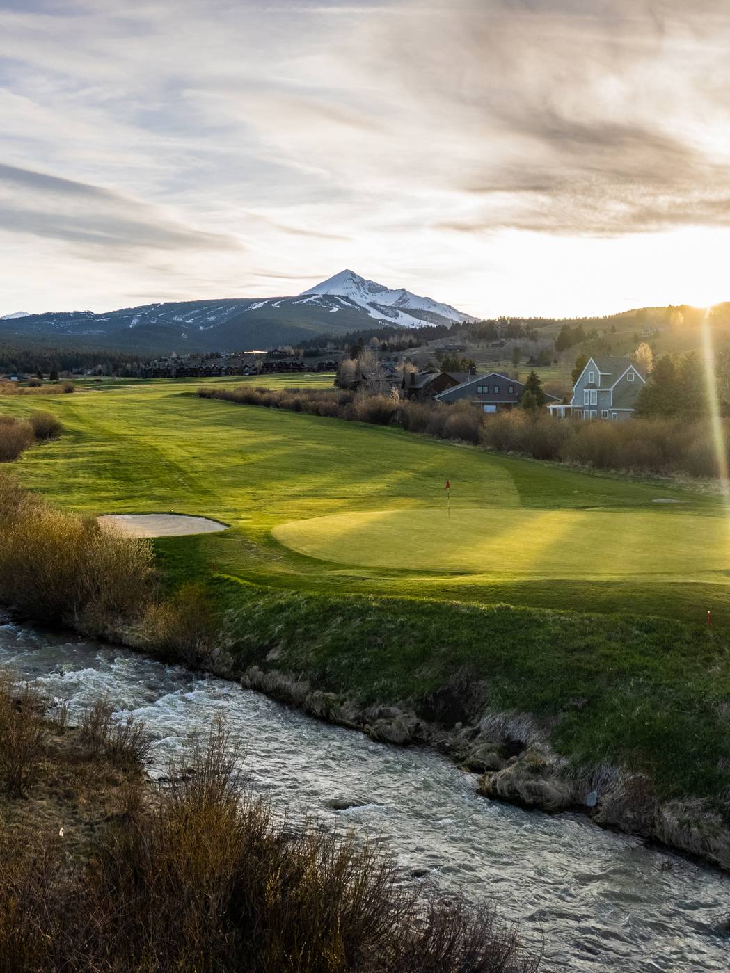 Golfer on a green with a mountain in the background