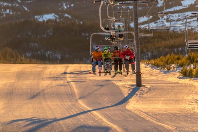 A group of skiers rides Southern Comfort chair above the run El Dorado