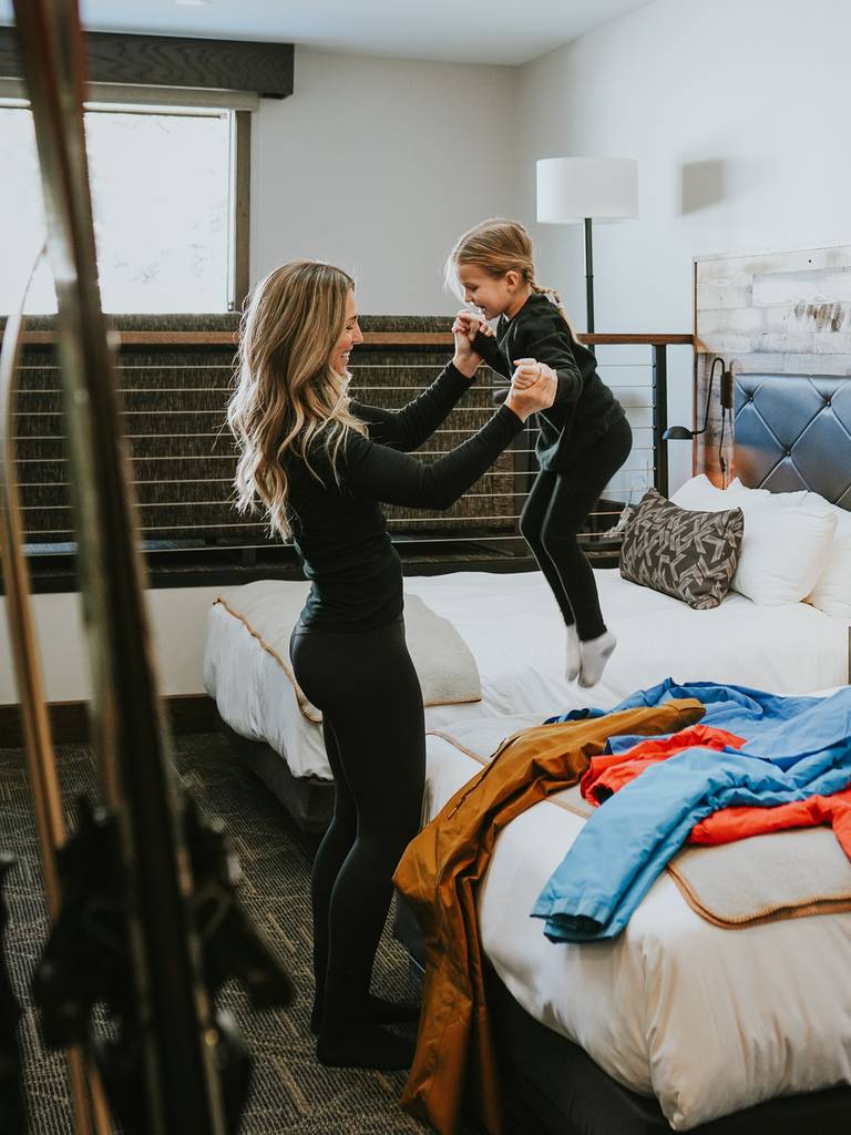 Mother and daughter getting dressed to ski in the Huntley Lodge