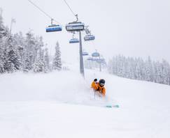 Powder skiing in front of a chairlift