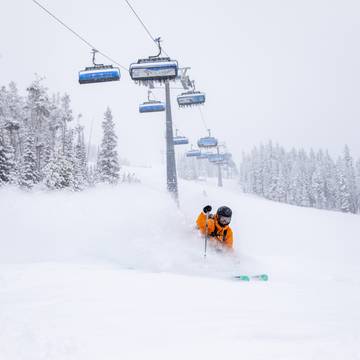 Powder skiing in front of a chairlift
