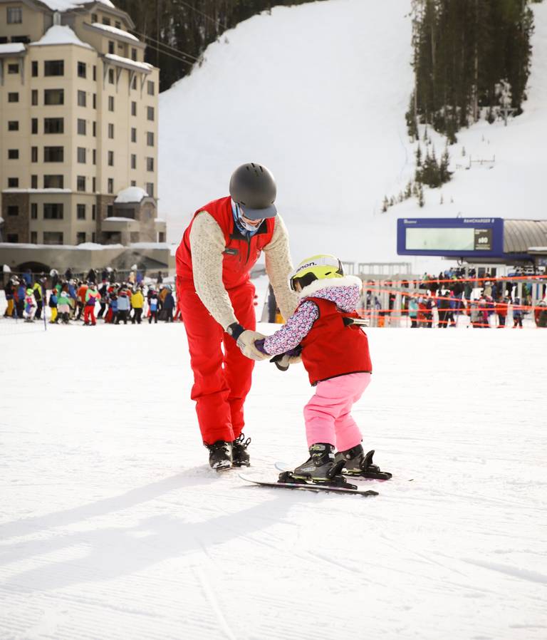 Small child and a ski instructor in a ski lesson