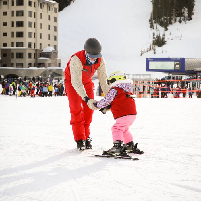 Small child and a ski instructor in a ski lesson
