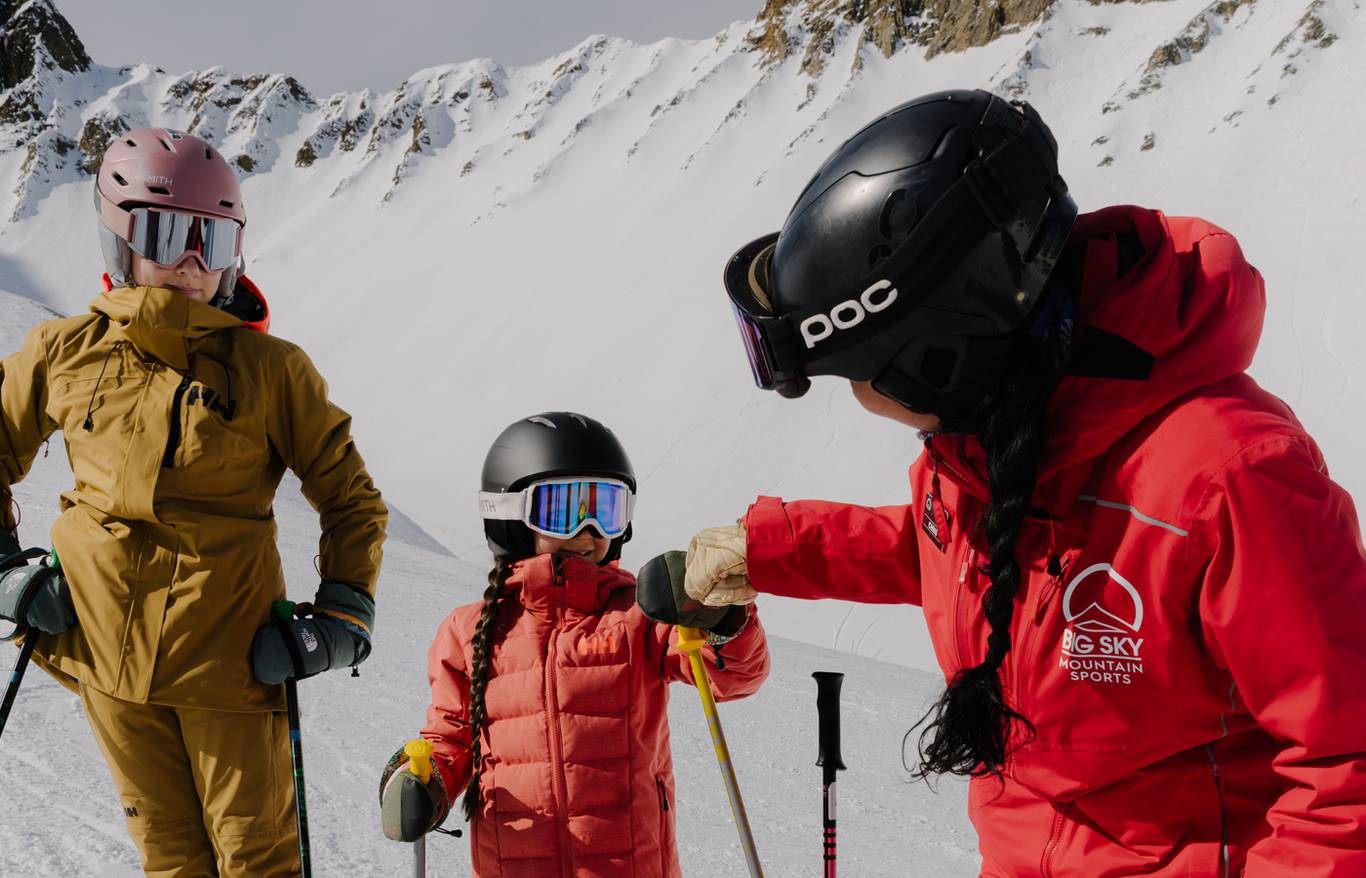 Girl fist-bumping a ski instructor