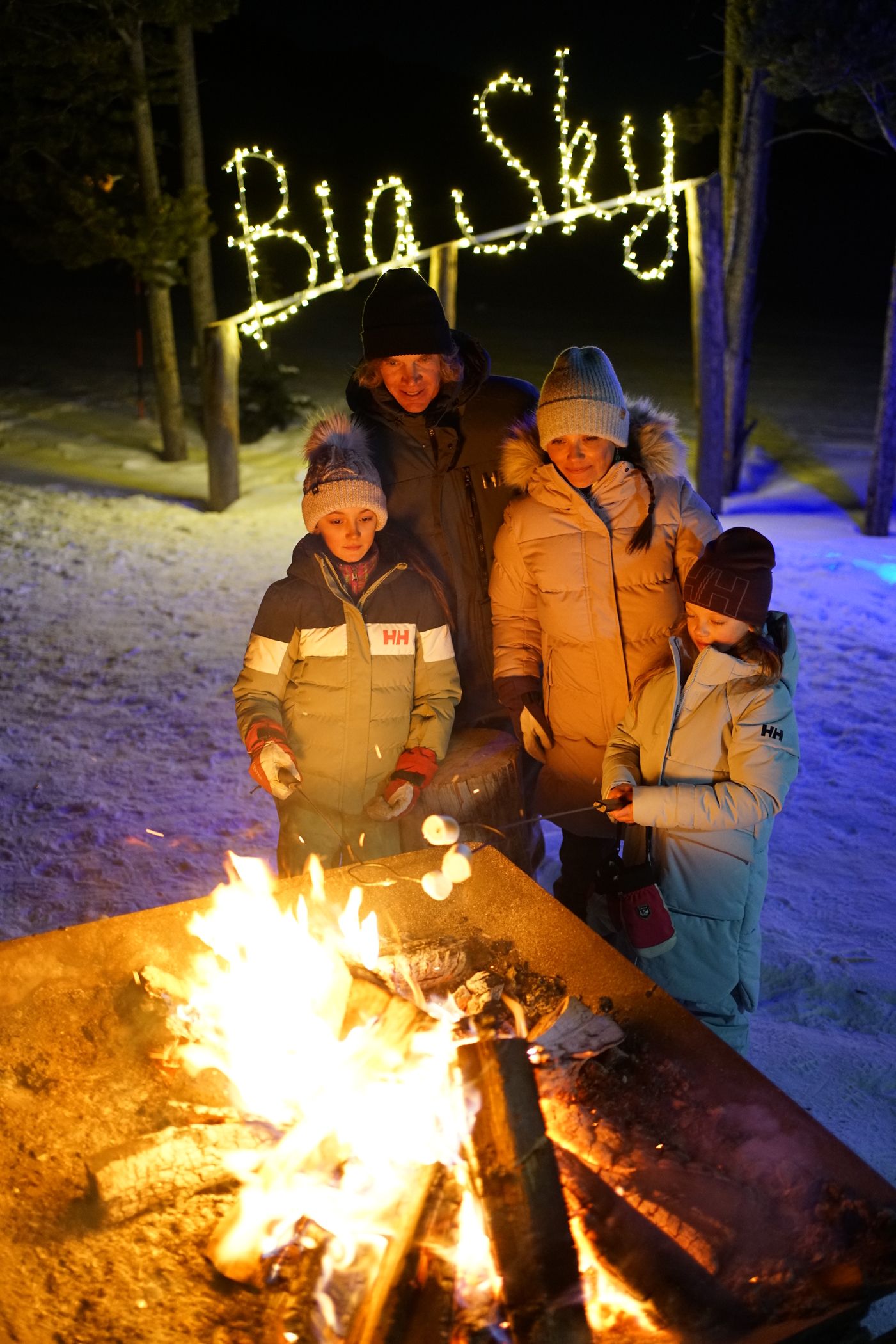 Family making smores in winter
