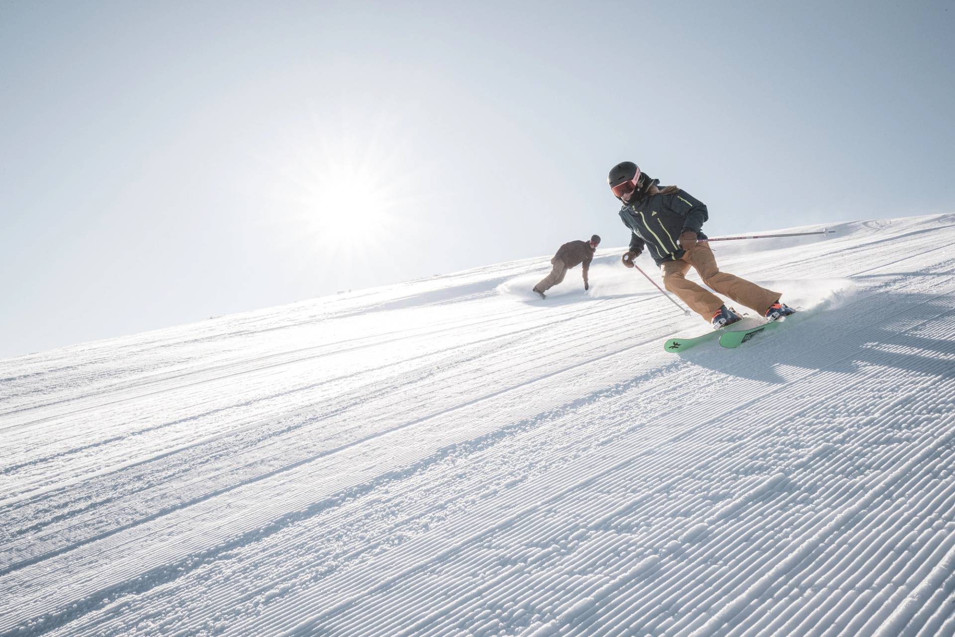 Skier and snowboarder on a groomed run
