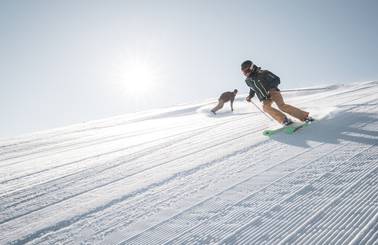 Skier and snowboarder on a groomed run