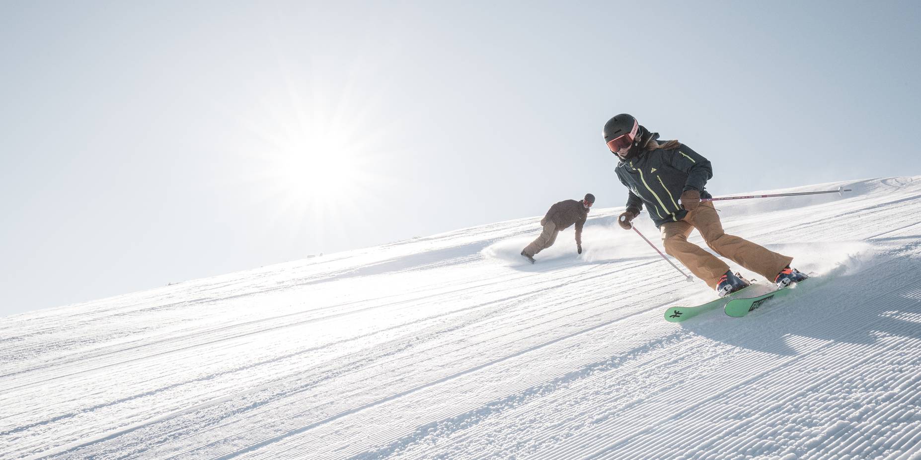 Skier and snowboarder on a groomed run at Big Sky Resort