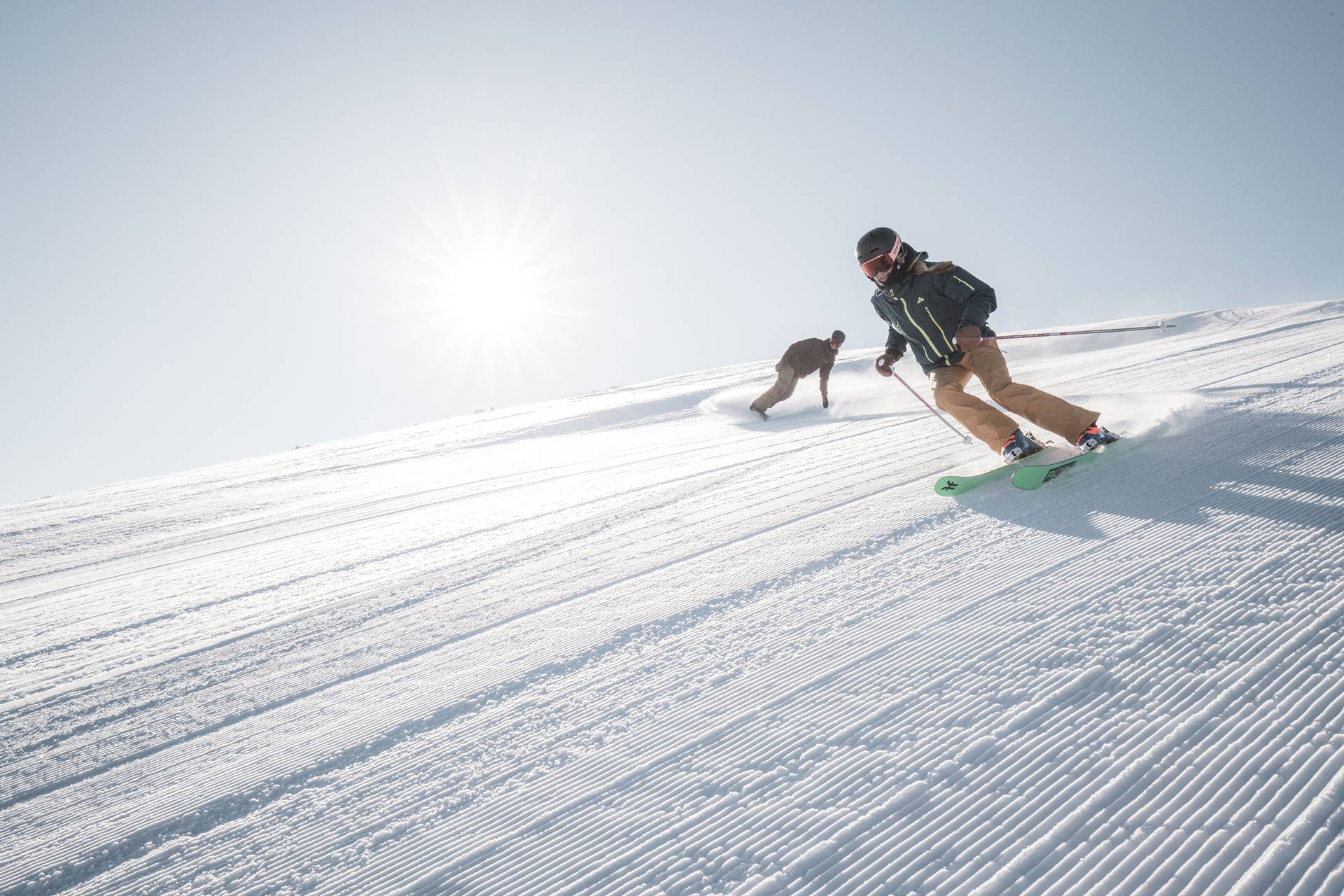 Skier and snowboarder on a groomed run