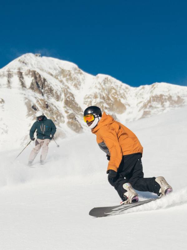 Skier and snowboarder on a groomed run